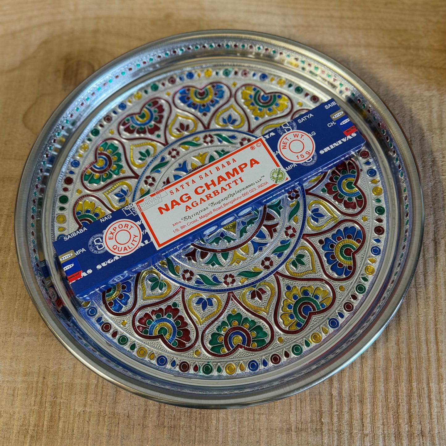 The Mandala Offering Tray is a beautifully decorated Indian dish made from aluminum. It is traditionally used for offering items such as candles, incense, flowers, or food in ceremonies and rituals.

Key Features:
Material: Aluminum, with intricate mandala decorations.
Traditional Use: Perfect for placing offerings like flowers, food, candles, or incense.
Size: 28 cm diameter and 2.5 cm height.
Care Note: Not heat-resistant. Ensure to use a fireproof surface when burning candles or incense on the tray to pr