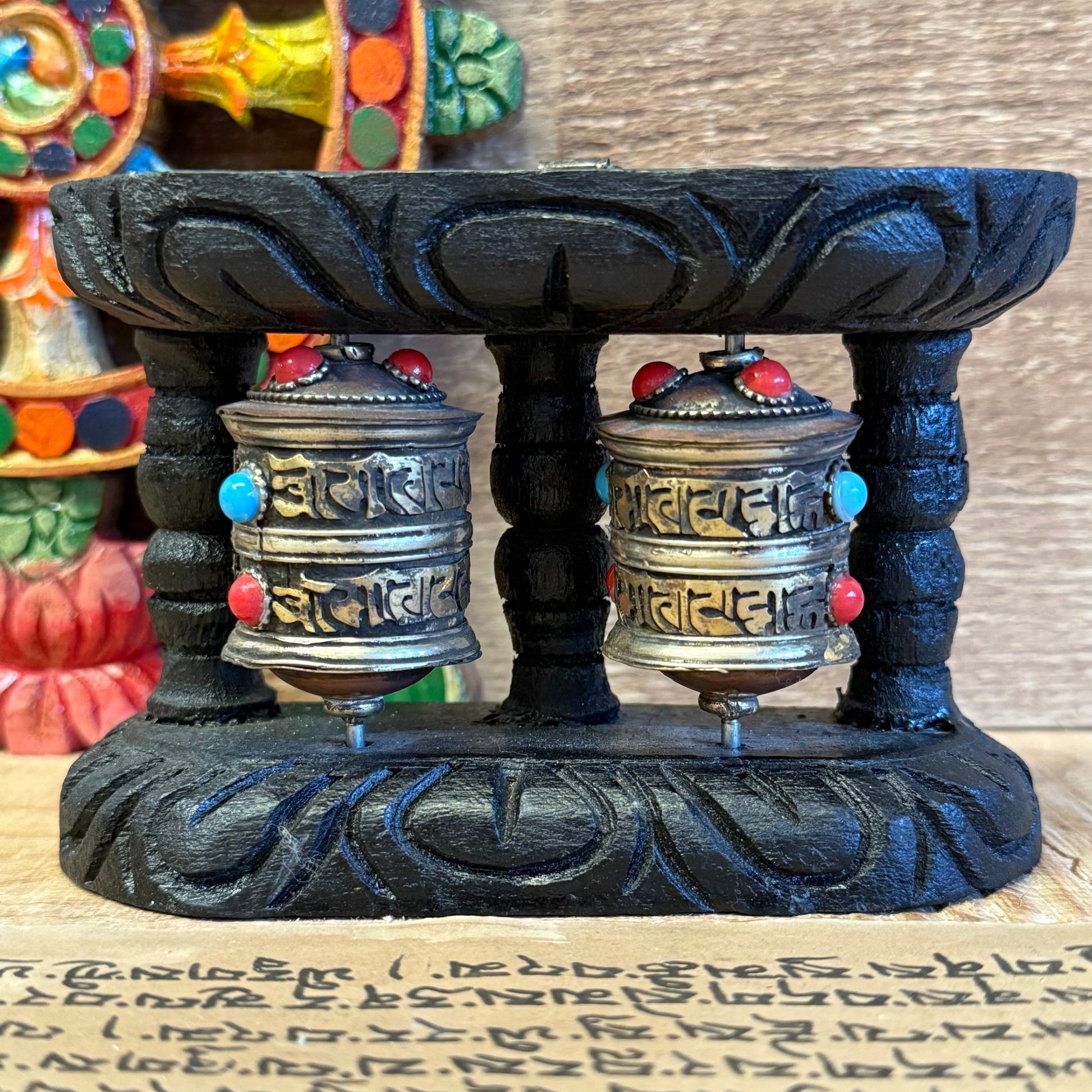 In the quiet rhythm of life, let your surroundings be embraced by the sacred sounds of the Om Mani Padme Hum mantra. This double prayer wheel is expertly fashioned from copper and mounted within a dark wooden frame, embodying the ancient Tibetan tradition of spreading blessings with every turn.

Fitted with a convenient hook for wall hanging, this rotating metal prayer wheel is filled and inscribed with the sacred mantra, promising the same meritorious effect as a spoken chant. Crafted under Fair Trade cond