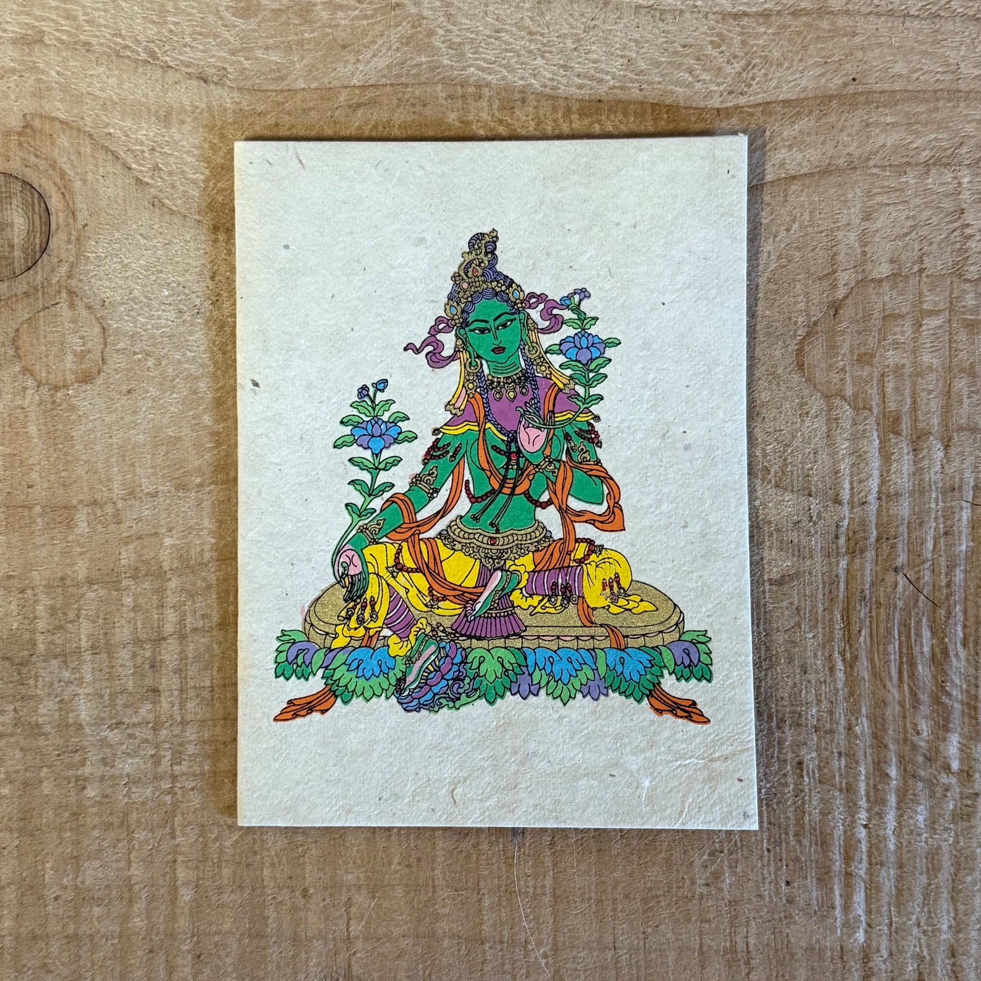 Invoke the swift compassion of Green Tara with this handcrafted Lokta Paper Greeting Card. Created by master artist Jimmy Thapa, each card is made using traditional Himalayan Lokta fibre, offering a sustainable and spiritually resonant finish. Blank inside with a matching envelope, it is ideal for blessings, celebrations, and meaningful correspondence. Natural colour and size variations reflect its handmade origin. Approx. 11 x 15 cm.