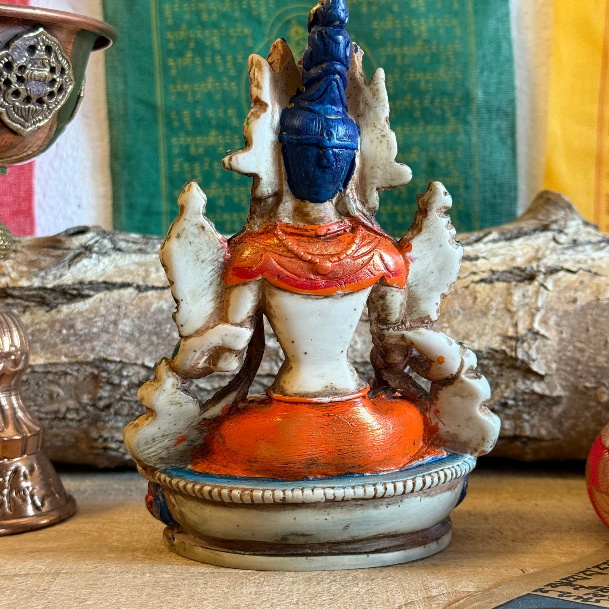 This is a beautifully intricate, handcrafted resin statue depicting White Tara, a revered goddess in Tibetan Buddhism. Known for her embodiment of compassion, healing, serenity, and longevity, she is a symbol of peace and enlightenment. The statue is skillfully painted and highlights White Tara's unique attributes:

Posture: She is seated in a tranquil, full lotus position, which signifies her meditative and composed nature, in contrast to Green Tara's more active pose with one foot extended.
Gesture: Her r