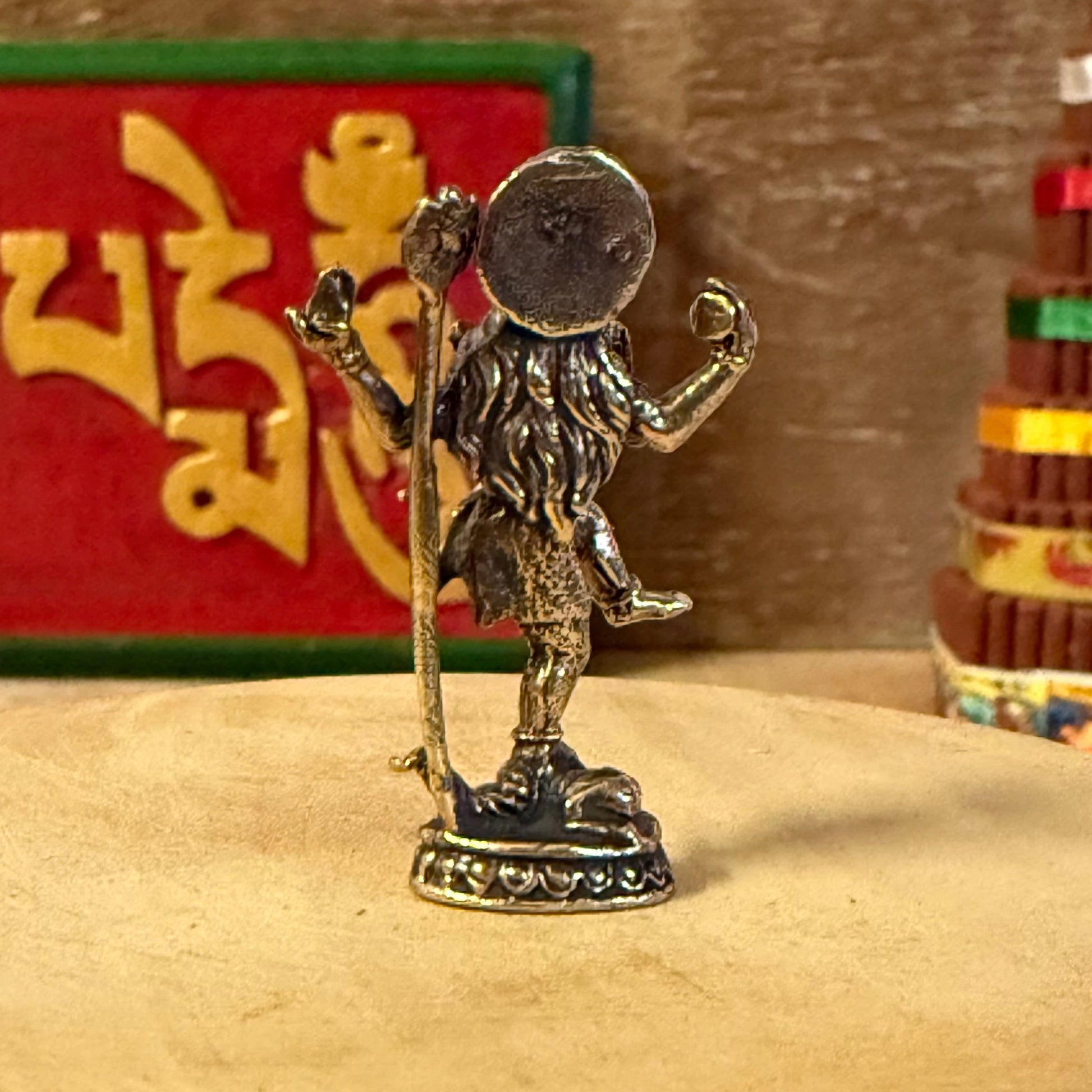 Bronze statue of a figure on a wooden surface with a colorful box in the background