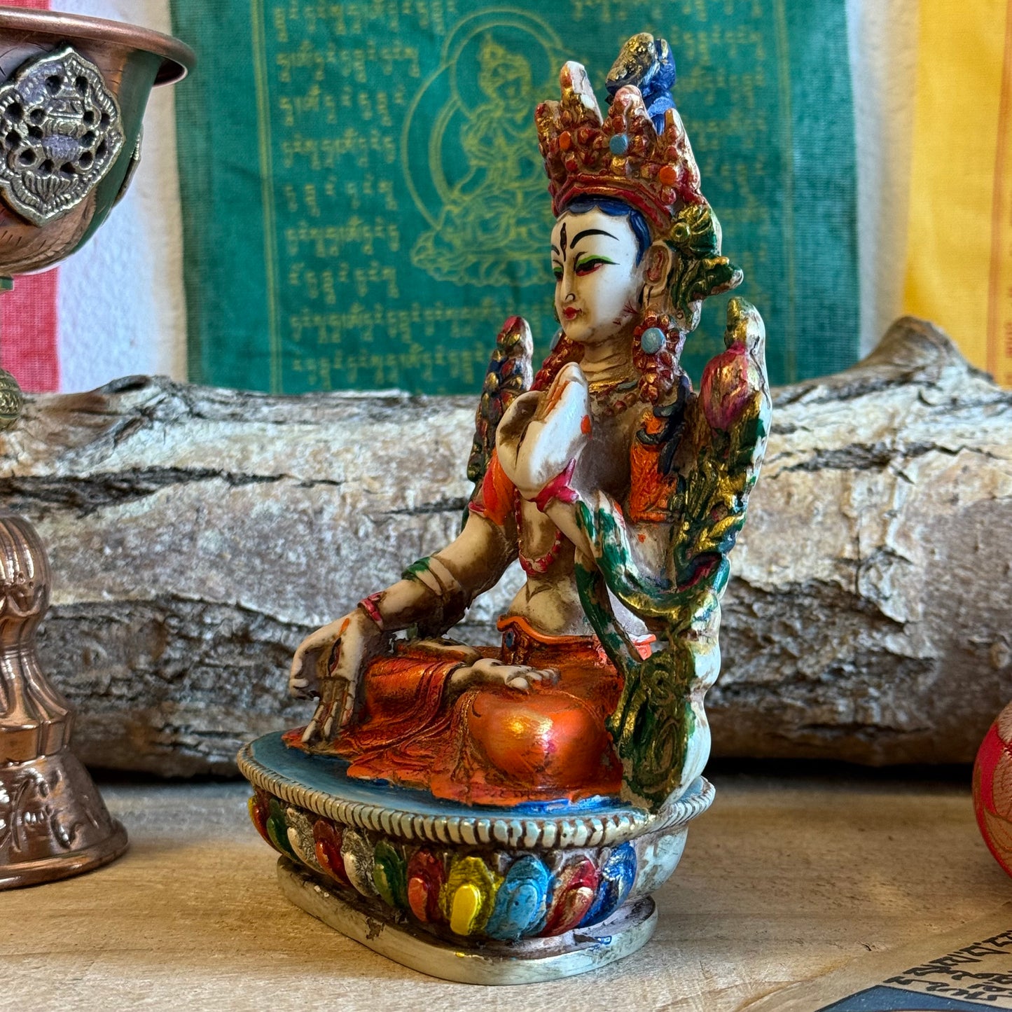 This is a beautifully intricate, handcrafted resin statue depicting White Tara, a revered goddess in Tibetan Buddhism. Known for her embodiment of compassion, healing, serenity, and longevity, she is a symbol of peace and enlightenment. The statue is skillfully painted and highlights White Tara's unique attributes:

Posture: She is seated in a tranquil, full lotus position, which signifies her meditative and composed nature, in contrast to Green Tara's more active pose with one foot extended.
Gesture: Her r