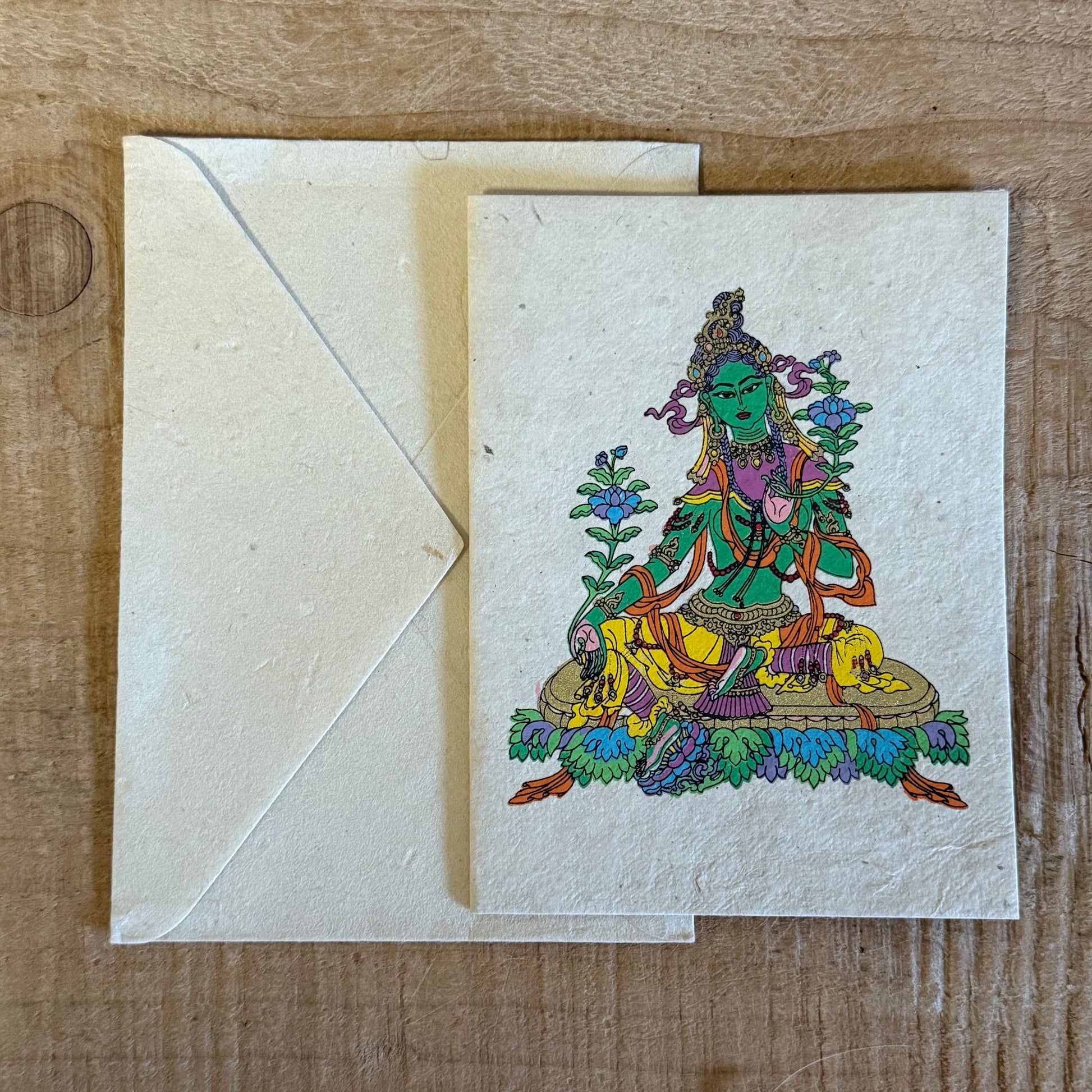 Invoke the swift compassion of Green Tara with this handcrafted Lokta Paper Greeting Card. Created by master artist Jimmy Thapa, each card is made using traditional Himalayan Lokta fibre, offering a sustainable and spiritually resonant finish. Blank inside with a matching envelope, it is ideal for blessings, celebrations, and meaningful correspondence. Natural colour and size variations reflect its handmade origin. Approx. 11 x 15 cm.