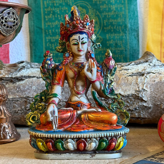 This is a beautifully intricate, handcrafted resin statue depicting White Tara, a revered goddess in Tibetan Buddhism. Known for her embodiment of compassion, healing, serenity, and longevity, she is a symbol of peace and enlightenment. The statue is skillfully painted and highlights White Tara's unique attributes:

Posture: She is seated in a tranquil, full lotus position, which signifies her meditative and composed nature, in contrast to Green Tara's more active pose with one foot extended.
Gesture: Her r