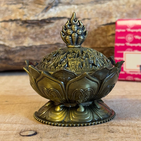 Enhance your home’s ambiance with this beautiful brass cone holder, thoughtfully designed in the shape of a lotus flower. Whether used for burning incense cones or as a charming decorative piece, this holder is both functional and elegant.

Key Features:
Elegant Lotus Design: The intricate lotus flower shape symbolizes purity and serenity, making it a meaningful addition to any space.
Majestic Smoke Display: Watch as the smoke gracefully curls through the lid’s opening, creating a soothing and captivating e