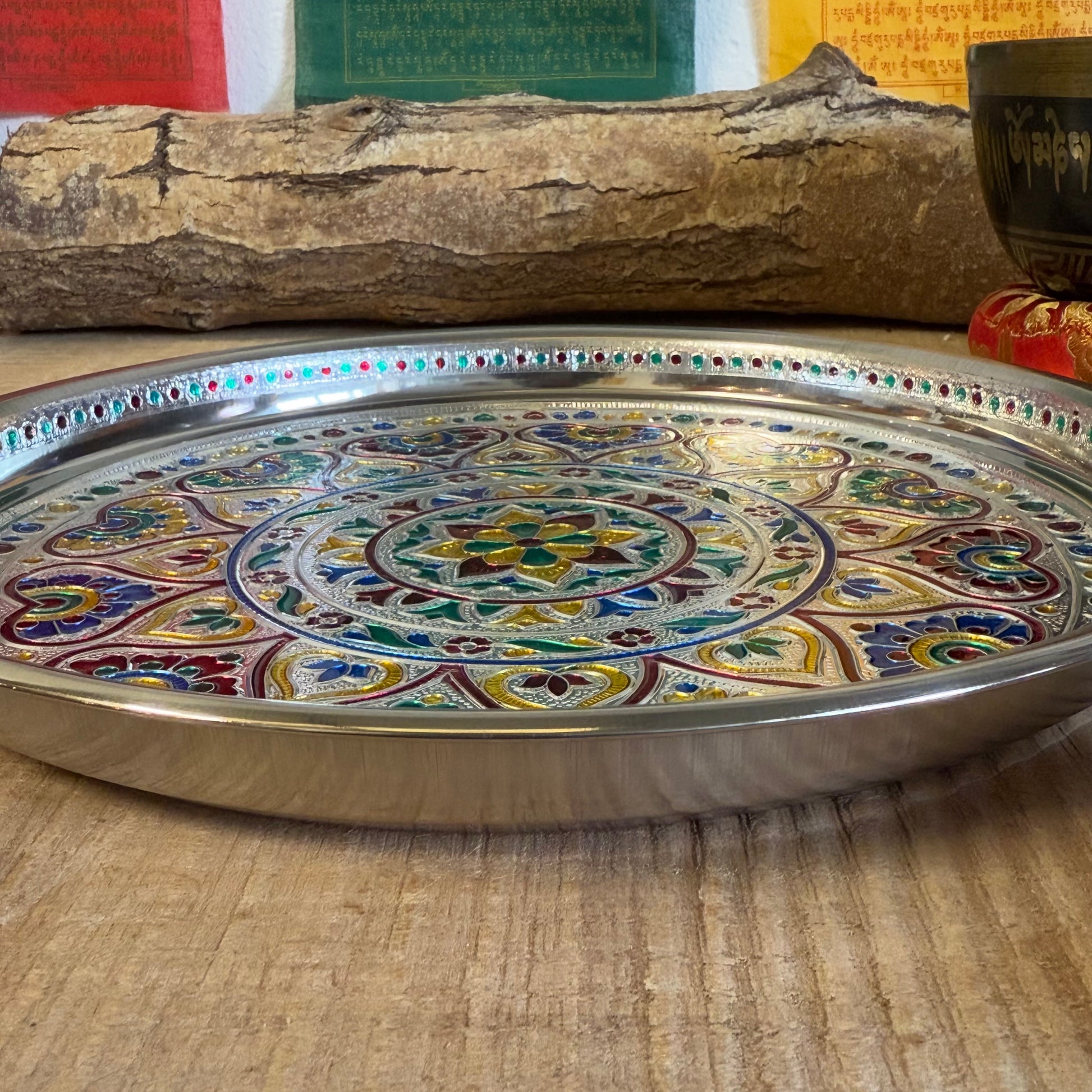 The Mandala Offering Tray is a beautifully decorated Indian dish made from aluminum. It is traditionally used for offering items such as candles, incense, flowers, or food in ceremonies and rituals.

Key Features:
Material: Aluminum, with intricate mandala decorations.
Traditional Use: Perfect for placing offerings like flowers, food, candles, or incense.
Size: 28 cm diameter and 2.5 cm height.
Care Note: Not heat-resistant. Ensure to use a fireproof surface when burning candles or incense on the tray to pr