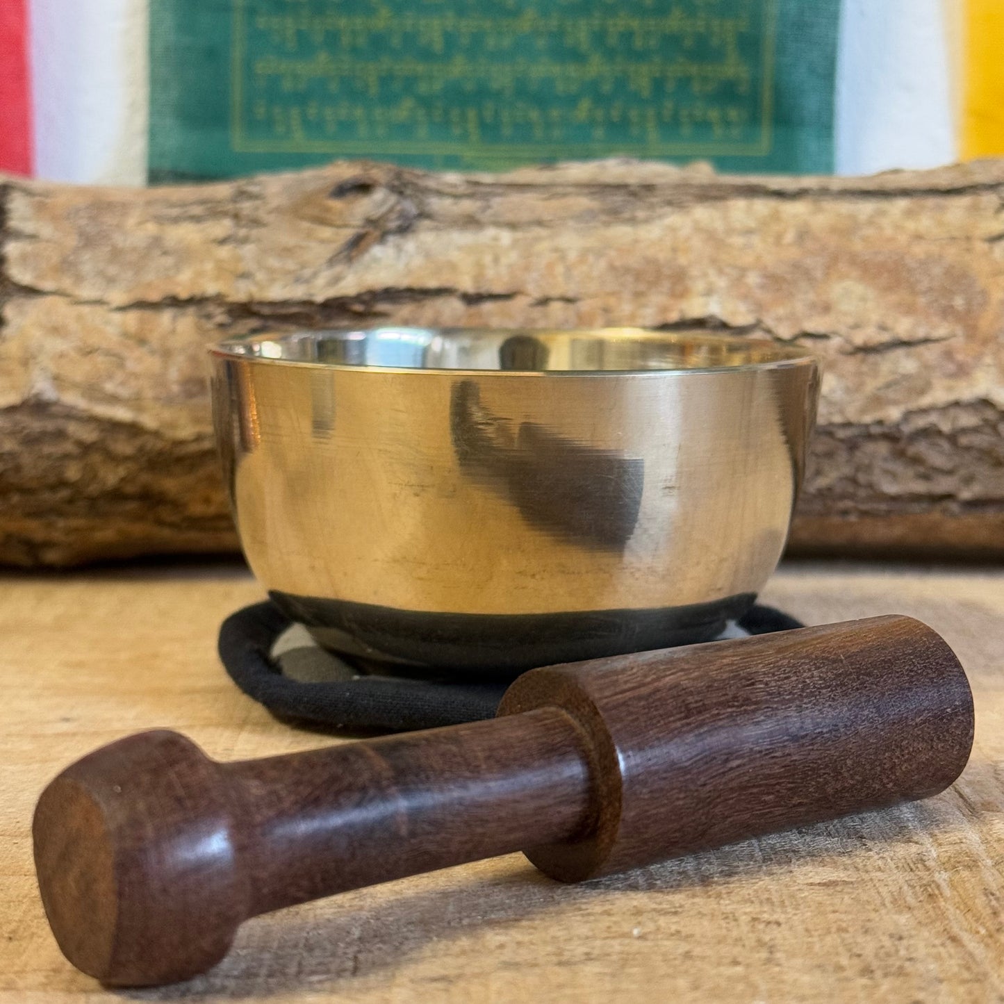 Singing bowl gift set and it contains a machine made brass singing bowl, a wooden striker and a simple cushion; all presented in an elegant handmade Himalayan Lokta paper box.