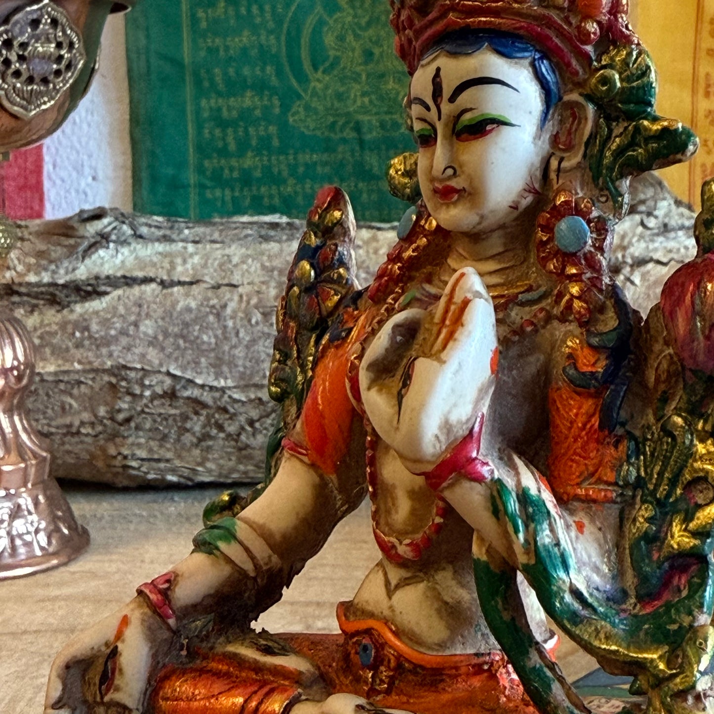 This is a beautifully intricate, handcrafted resin statue depicting White Tara, a revered goddess in Tibetan Buddhism. Known for her embodiment of compassion, healing, serenity, and longevity, she is a symbol of peace and enlightenment. The statue is skillfully painted and highlights White Tara's unique attributes:

Posture: She is seated in a tranquil, full lotus position, which signifies her meditative and composed nature, in contrast to Green Tara's more active pose with one foot extended.
Gesture: Her r