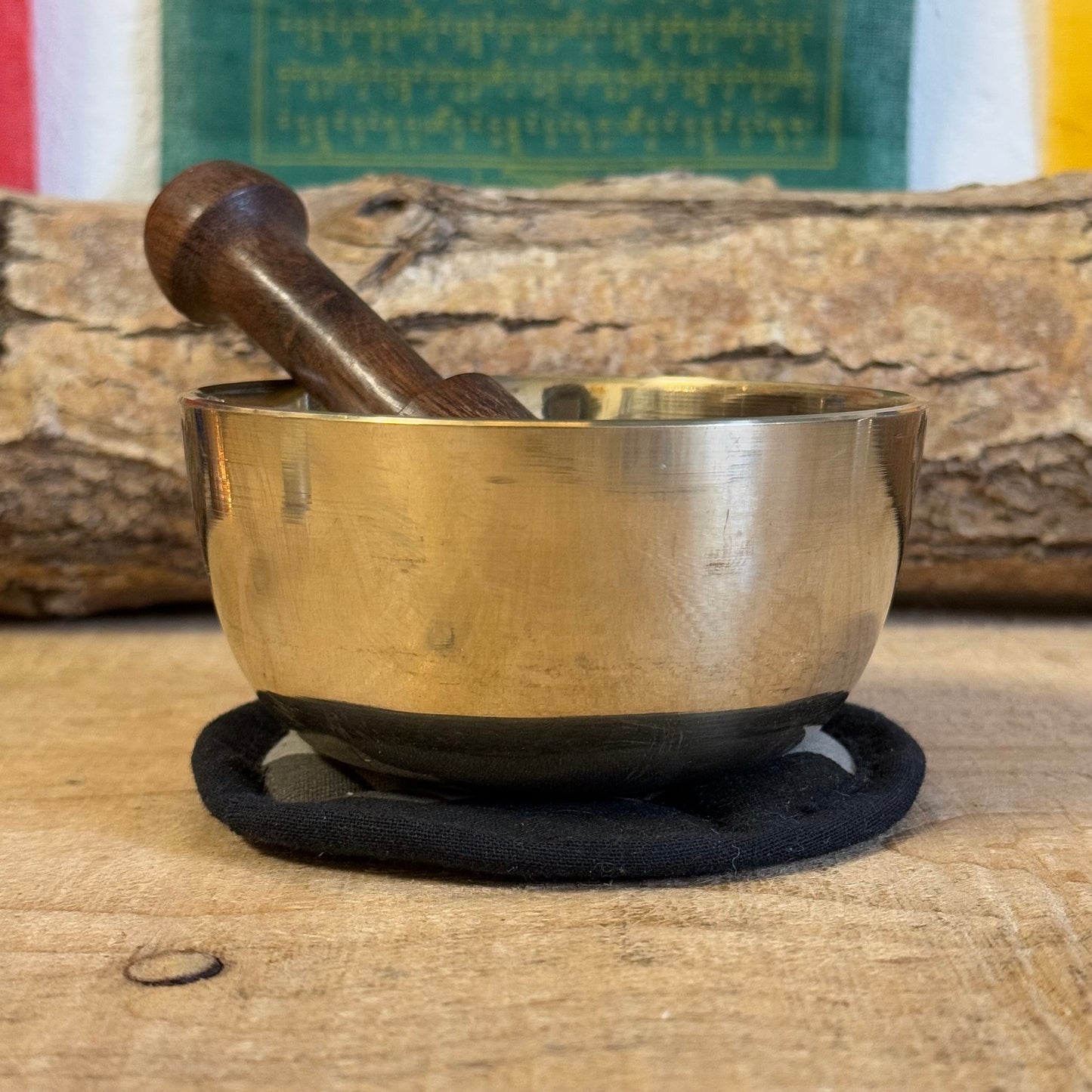 Singing bowl gift set and it contains a machine made brass singing bowl, a wooden striker and a simple cushion; all presented in an elegant handmade Himalayan Lokta paper box.