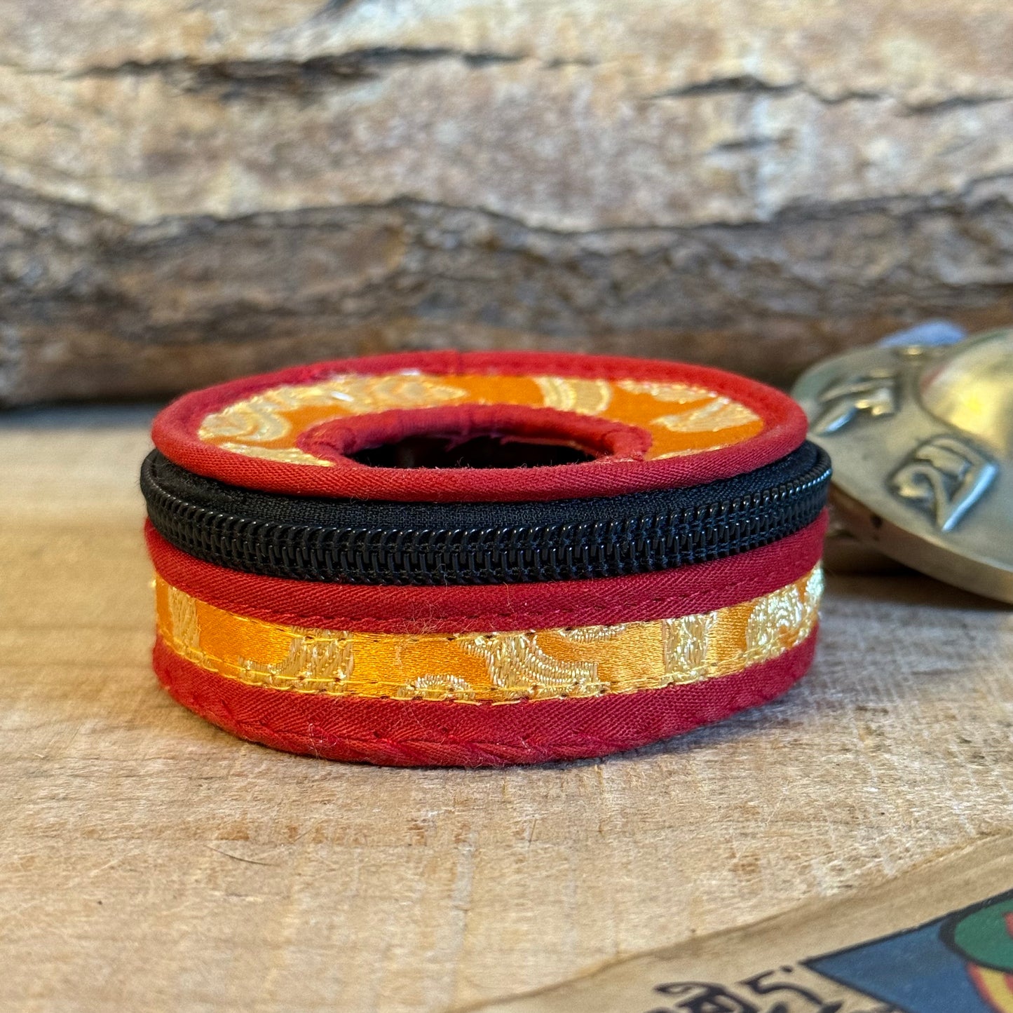 Protect your tingsha set with a beautiful brocade tingsha container.
This bag is made of orange/red&nbsp;cotton, lined on the inside and has a&nbsp;cotton&nbsp;in-between ring. Beautiful&nbsp;finish with a zipper.