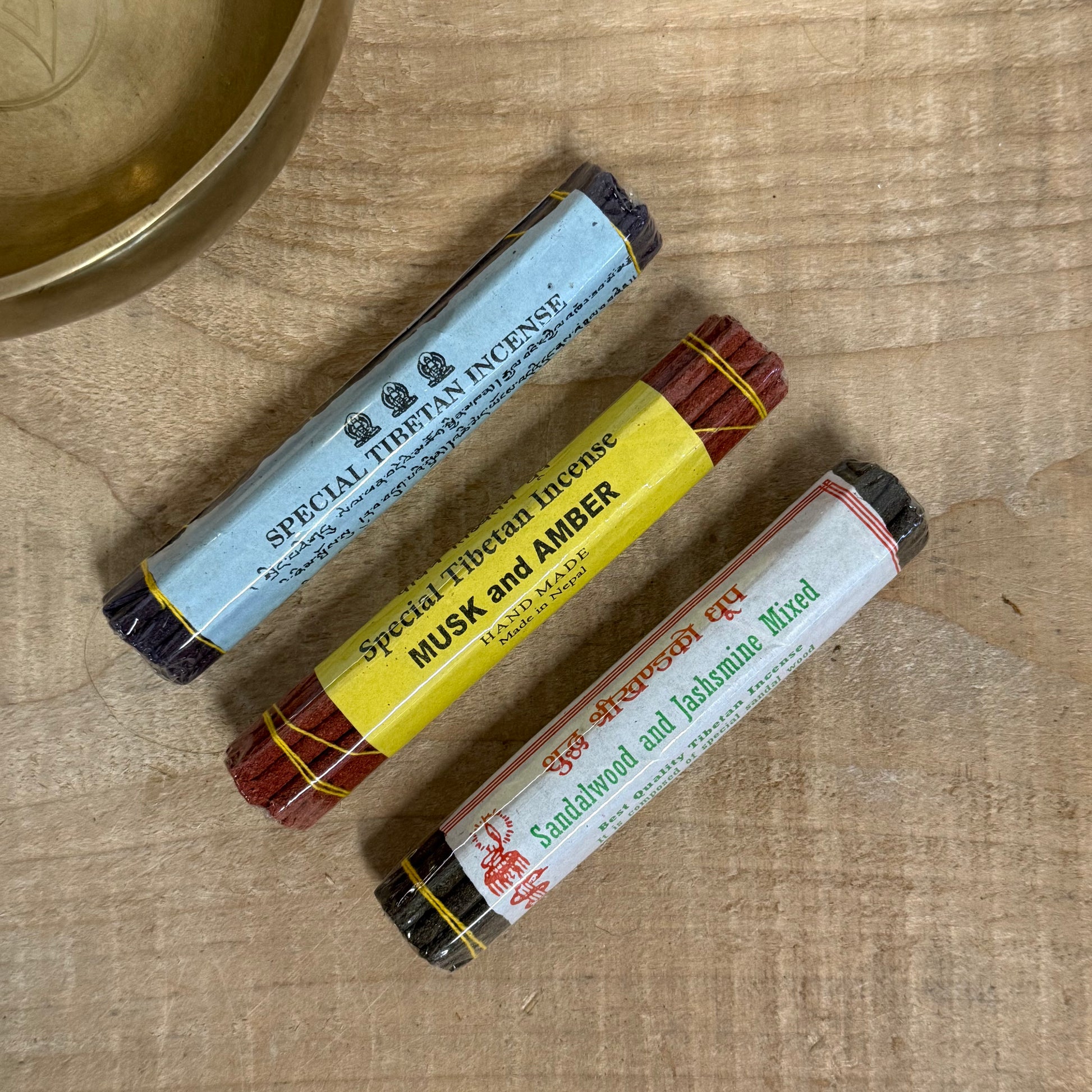Tibetan incense gift set with three incense packs, drawstring bag, and wooden holder.