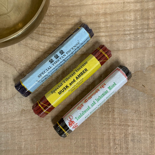 Tibetan incense gift set with three incense packs, drawstring bag, and wooden holder.