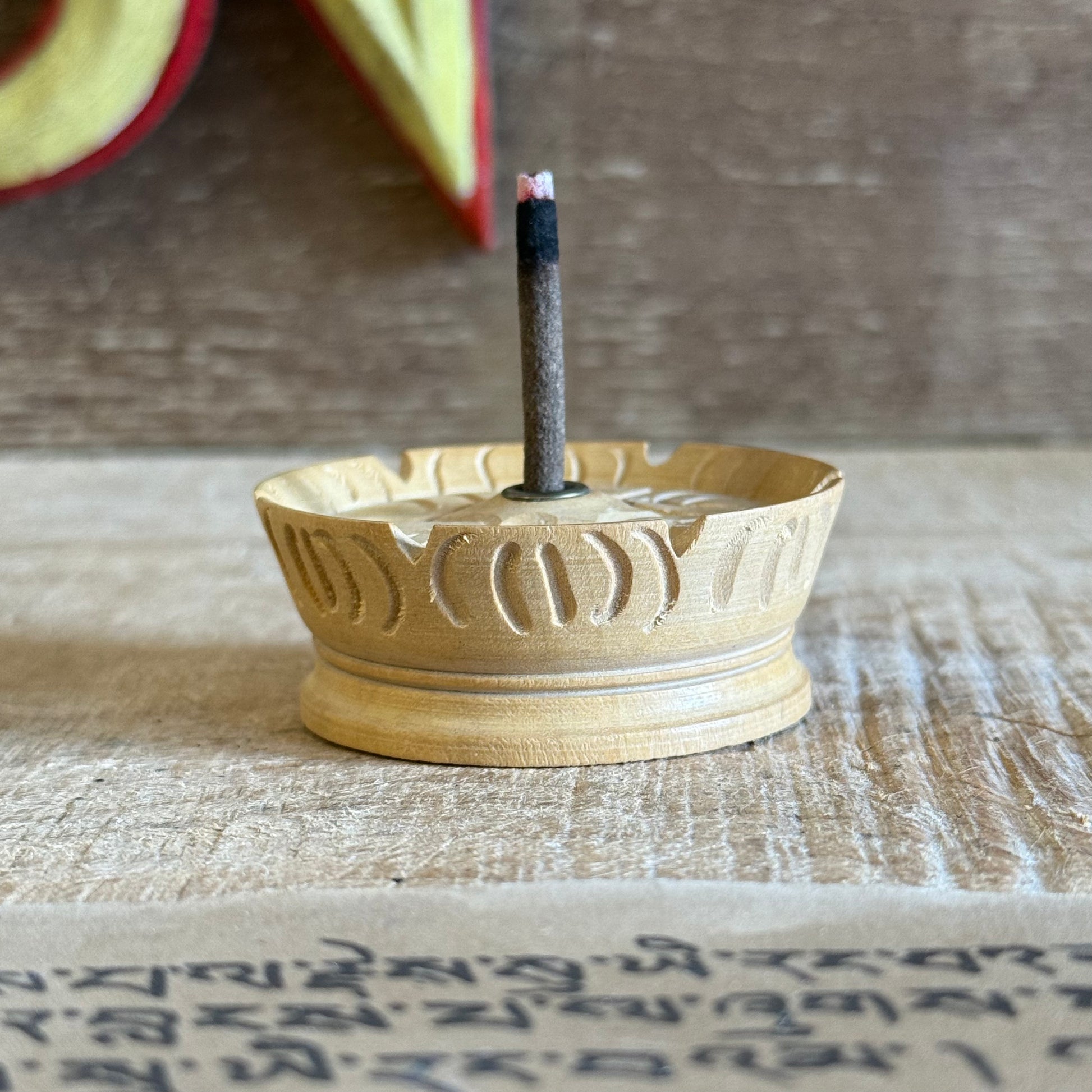This beloved Lotus Tibetan Incense Holder is a simple yet sacred companion for your incense practice. Hand-carved from a single piece of soft yellow wood in Nepal, each piece carries the gentle energy of mindful craftsmanship and Buddhist symbolism.

The lotus, carved into its form, is a profound symbol of spiritual awakening — rising from the mud to bloom in stillness and clarity. Its wide, rounded base is designed to safely catch falling ash, making it both beautiful and practical.