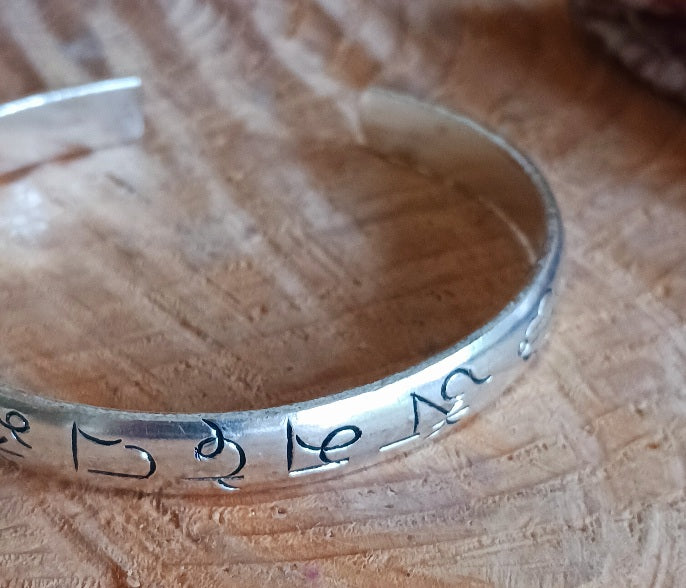 Experience the spiritual elegance of our Tibetan White Metal Bangles, intricately etched with the sacred Buddhist mantra, Om Mani Padme Hum. Each bangle is handcrafted with meticulous detail, reflecting traditional Tibetan artistry. Perfect as a meaningful gift, each piece comes beautifully presented in a traditional Tibetan pouch, making it ideal for meditation, mindfulness, or as a unique accessory that carries a message of peace and compassion.