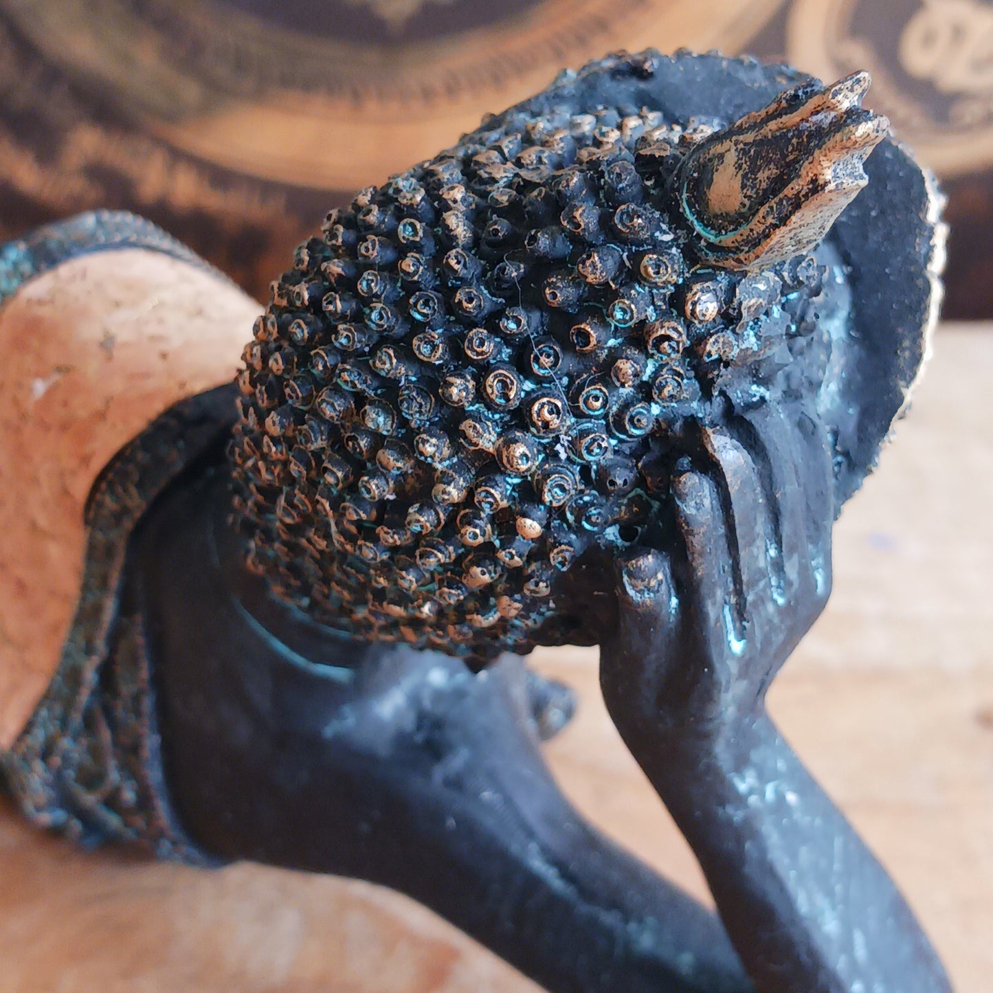 The statue features the Buddha in a graceful reclining pose, symbolizing his entry into nirvana. His left arm rests peacefully by his side, while his right hand cradles his head in a gesture of repose. The robe is intricately adorned with bodhi leaf motifs—sacred symbols of enlightenment and spiritual awakening.