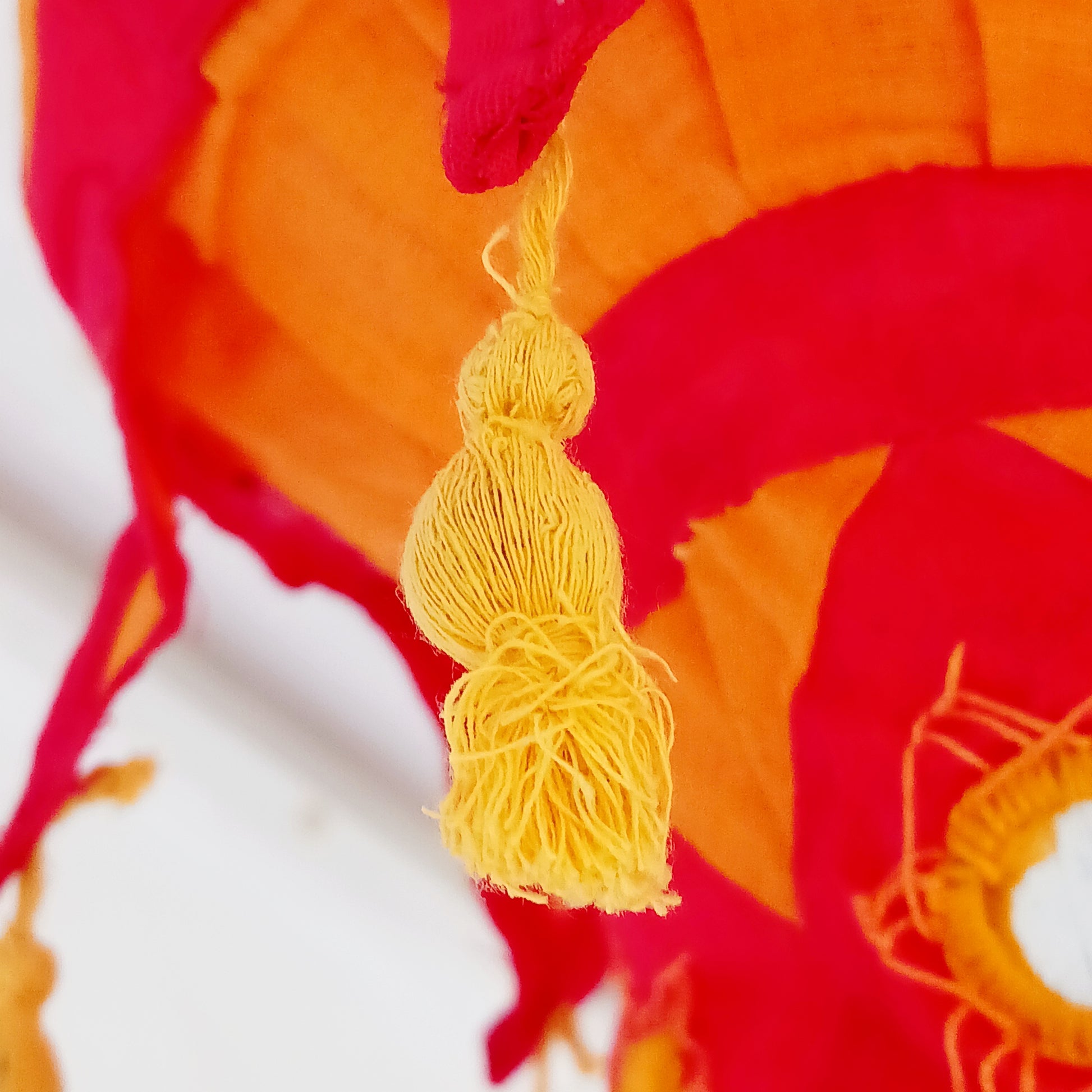 Bring colour, culture, and warmth into your space with this traditional handmade cotton Jhumar lampshade from Nepal. Carefully crafted by skilled artisans, each lampshade is made from vibrant cotton fabric and decorated with beautiful embroidered synthetic mirrors, creating a unique and eye-catching design.