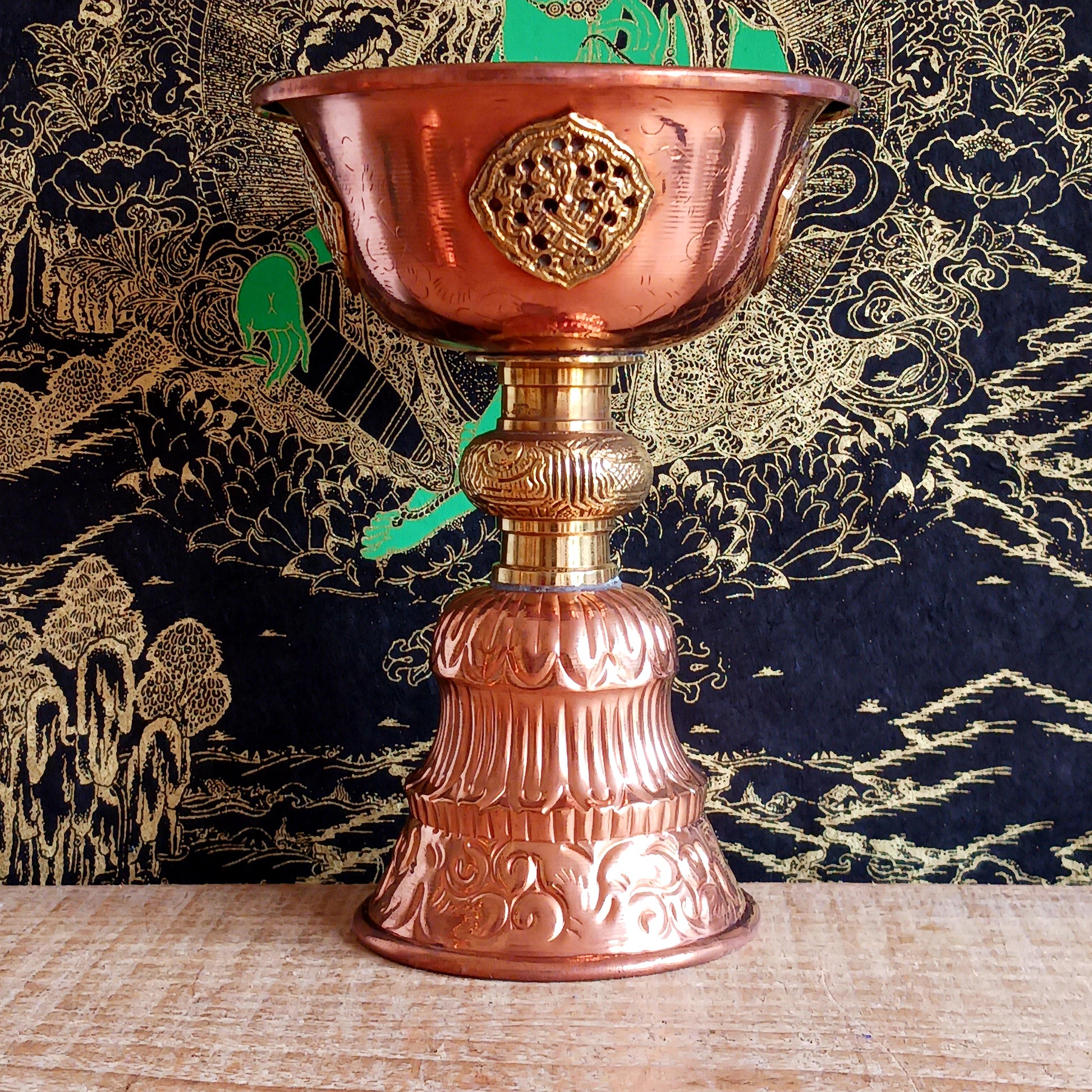 Illuminate your sacred space with this Large Copper Butter Lamp, beautifully handcrafted and engraved with traditional Tibetan auspicious symbols around the sides. Commonly used in Tibetan temples, these lamps are filled with yak butter, vegetable oil, or ghee and offered as a light to symbolize wisdom and clarity. Each morning, Tibetan Buddhists light butter lamps as a spiritual act of devotion and illumination. Perfect for altars, meditation spaces, or as a unique cultural centerpiece, this lamp brings bo