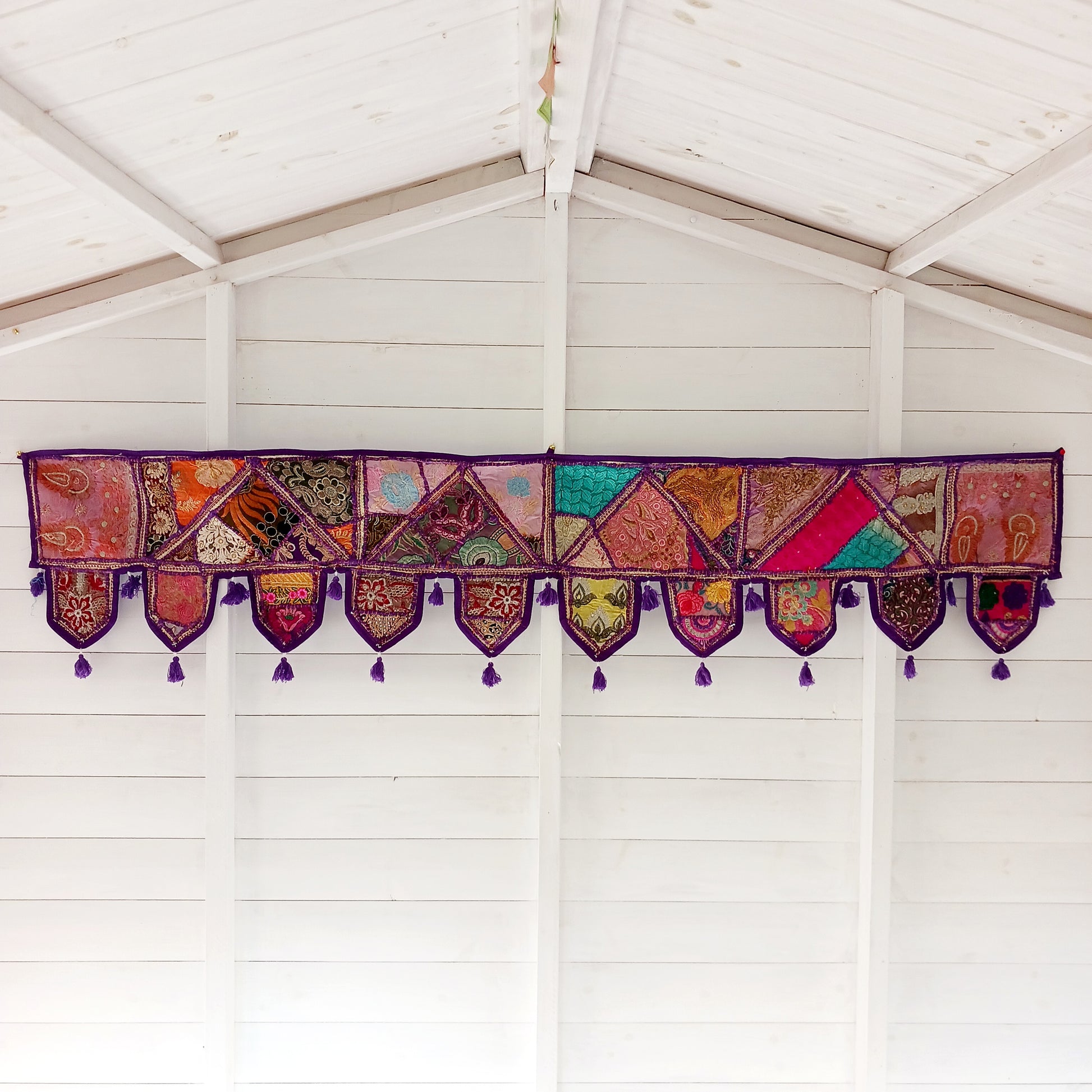 This long and beautifully intricate Indian Toran has been handmade from patches of vintage fabrics, wedding saris and recycled fabrics. It will be a unique addition to any home and bring vibrancy of colour and embellishment.