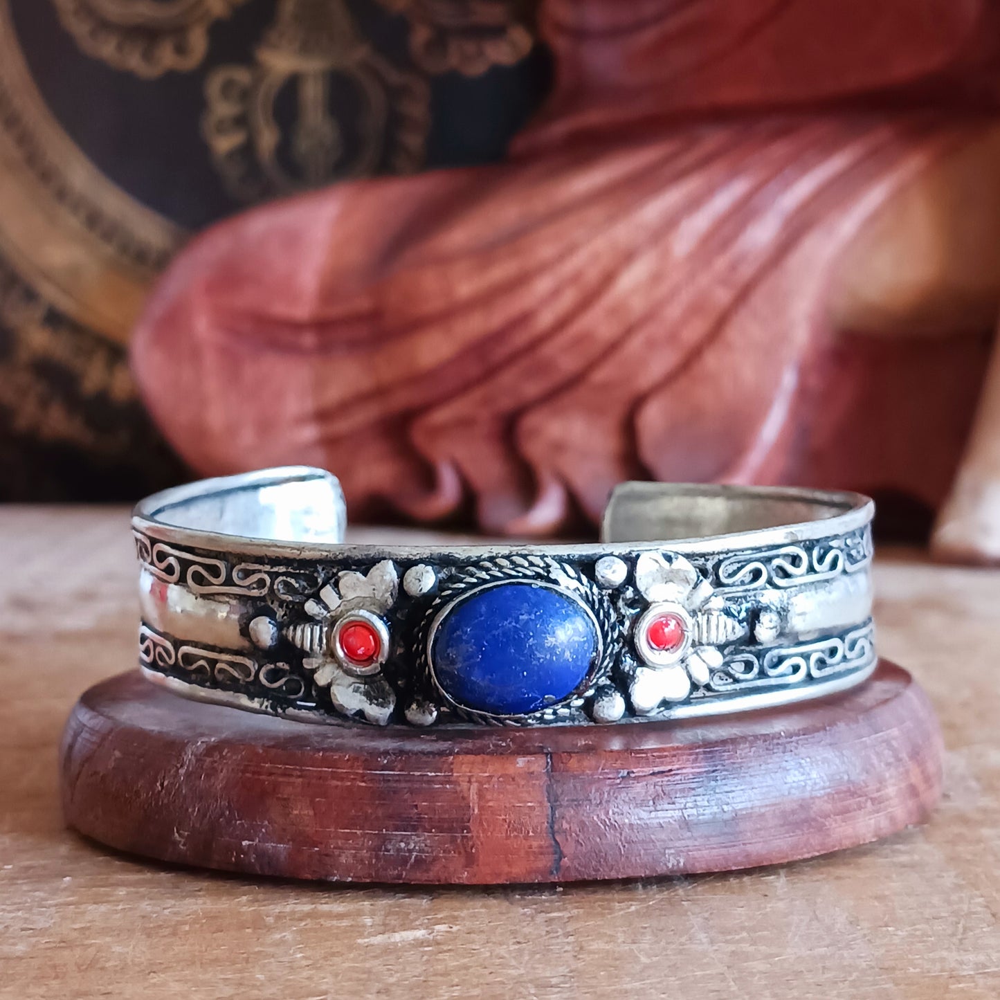 These beautifully handcrafted Nepalese white metal bangles feature a striking central lapis stone, delicately flanked by two drop coral beads. Each piece is individually made by skilled artisans in local Nepalese workshops, ensuring no two bangles are ever exactly alike.
