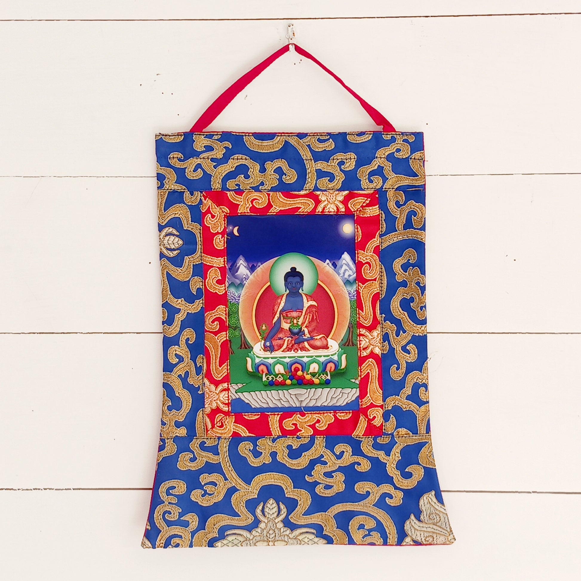 Bring healing energy, restoration, and spiritual harmony into your home with this beautiful Medicine Buddha Traditional Printed Thangka, elegantly presented in a handmade brocade frame.