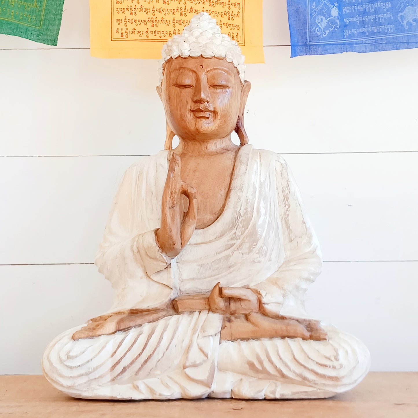 Bring calm, wisdom, and mindful intention into your space with this beautifully serene Teaching Buddha statue, hand-carved from sustainable Suar wood (Albizia Saman), a fast-growing and responsibly cultivated hardwood, finished in whitewash.
