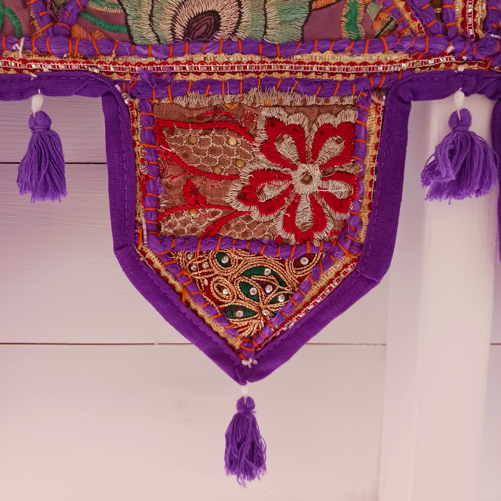 This long and beautifully intricate Indian Toran has been handmade from patches of vintage fabrics, wedding saris and recycled fabrics. It will be a unique addition to any home and bring vibrancy of colour and embellishment.