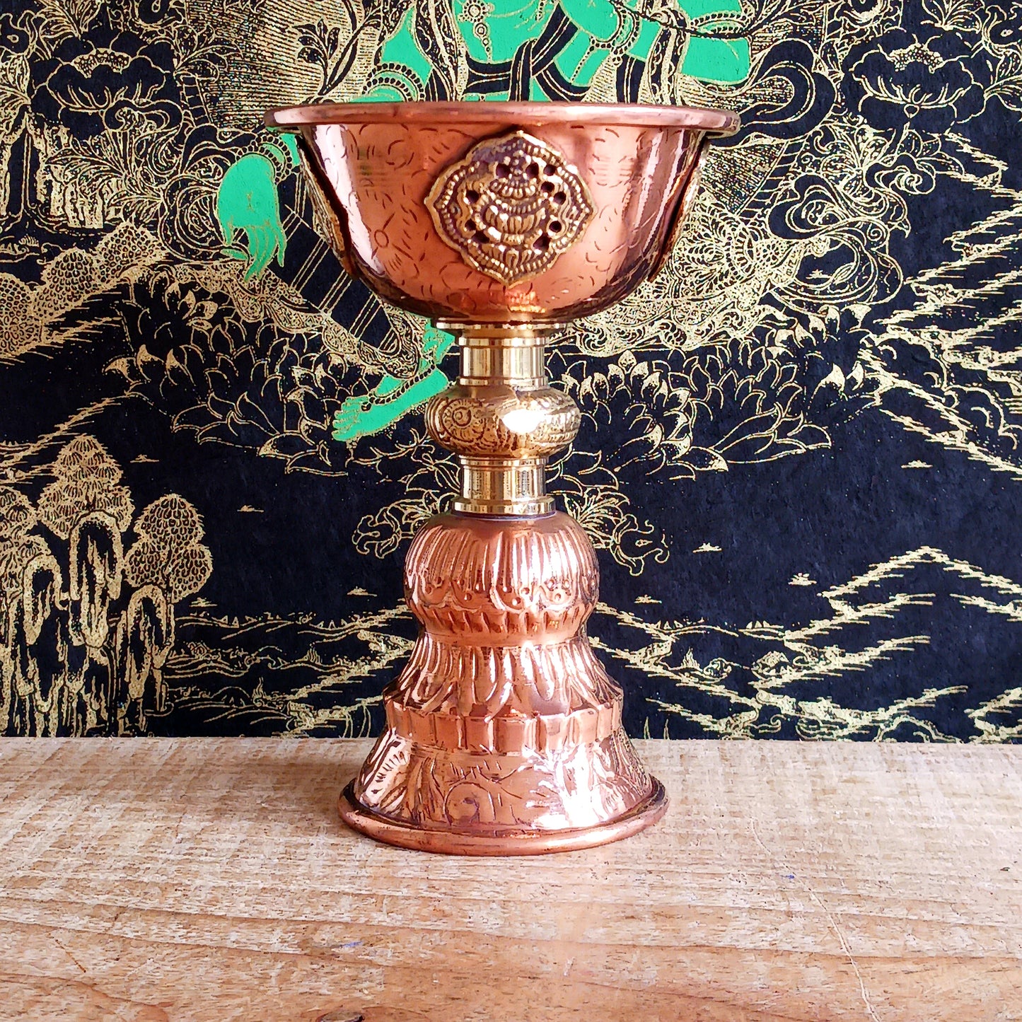 Illuminate your spiritual practice with this fine Traditional Tibetan Butter Lamp, handcrafted from high-quality copper and adorned with intricate Auspicious Symbols. These sacred lamps are a central element in Tibetan Buddhist rituals, symbolizing the light of wisdom dispelling the darkness of ignorance. Commonly found in Himalayan temples and monasteries, butter lamps are offered each morning by Tibetan Buddhists.