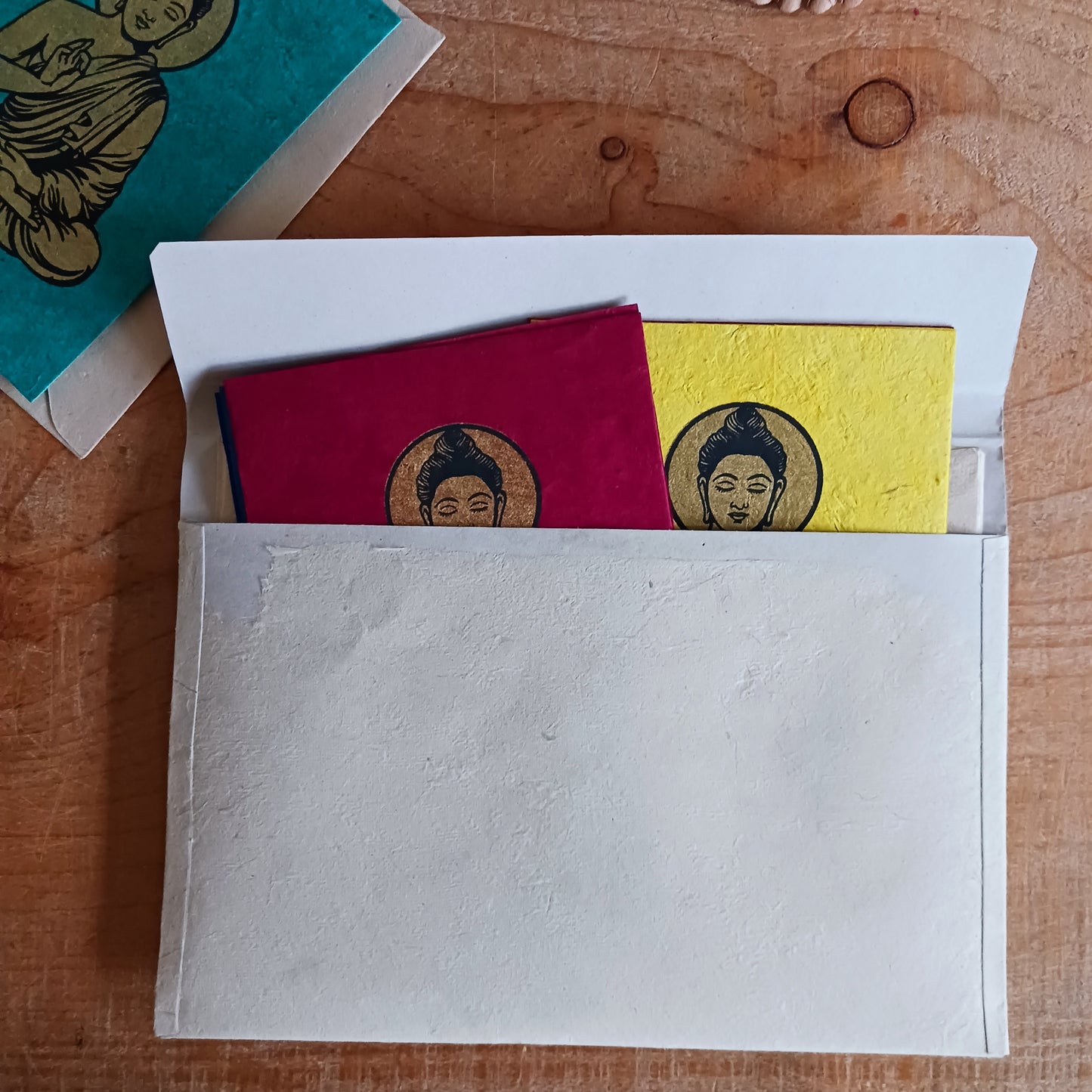 Share peace, colour, and meaningful craftsmanship with this beautifully decorated Buddha greeting card set, handmade from traditional Lokta paper. Sourced from the high-altitude Himalayan forests of Nepal, Lokta paper has been crafted for centuries using sustainable methods. The fast-growing Lokta bush regenerates quickly, making it an eco-friendly alternative to conventional paper.