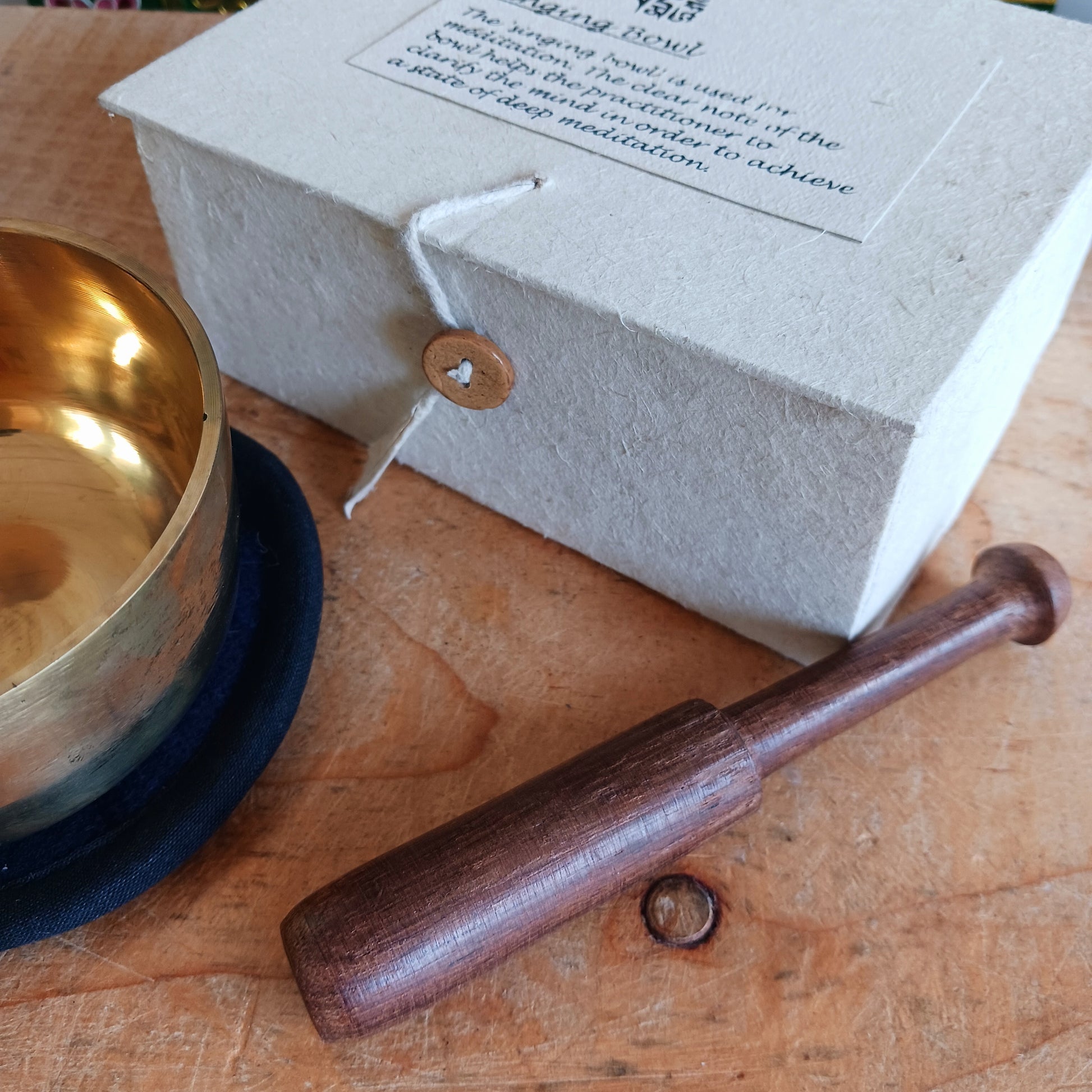 Discover the calming sound of mindfulness with this beautifully crafted Singing Bowl Gift Set. Ideal for beginners and children, the set includes a smooth, machine-made brass singing bowl that is easy to play, a wooden striker, and a soft cushion—all elegantly presented in a handmade Himalayan Lokta paper box.