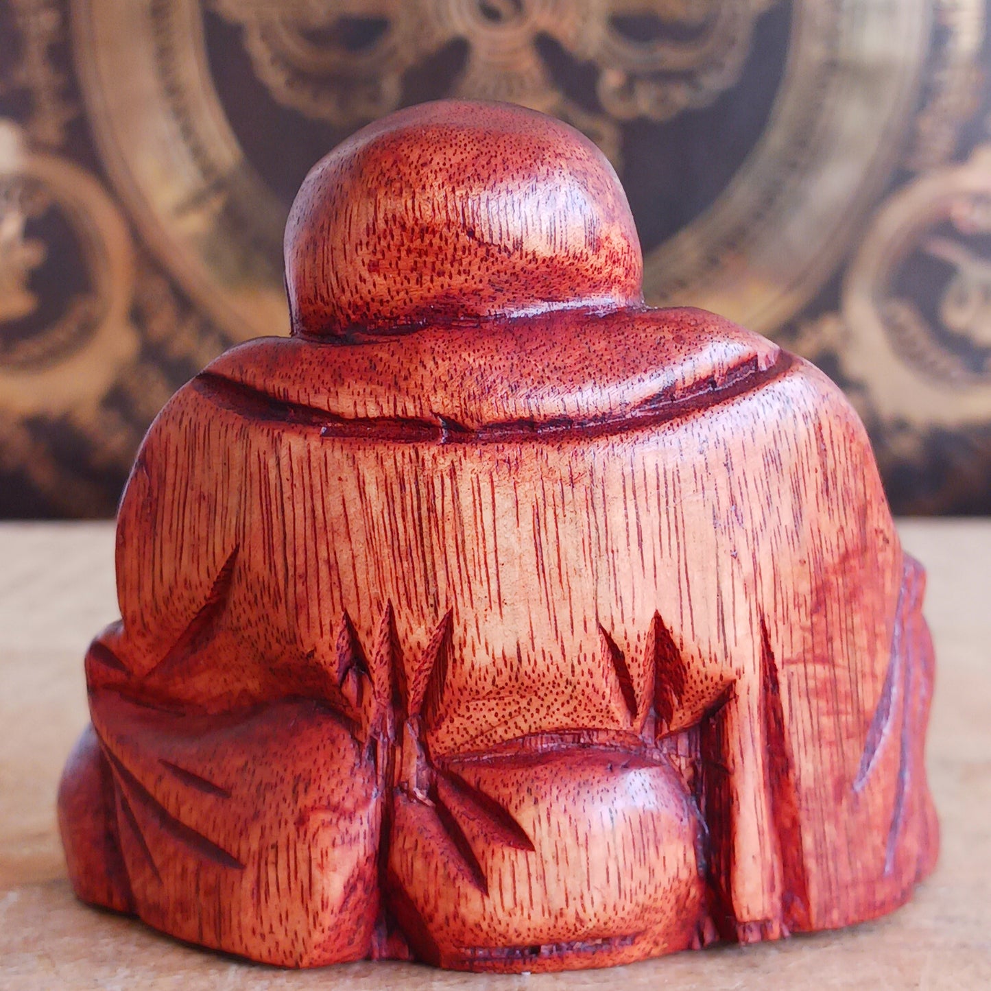 This mini hard carved wooden Laughing Buddha statue represents Budai, the beloved figure of joy, abundance, and contentment in Buddhist tradition. Carved in wood and full of character, Budai is traditionally depicted as a bald monk with a joyful smile, wearing simple robes and holding prayer beads.