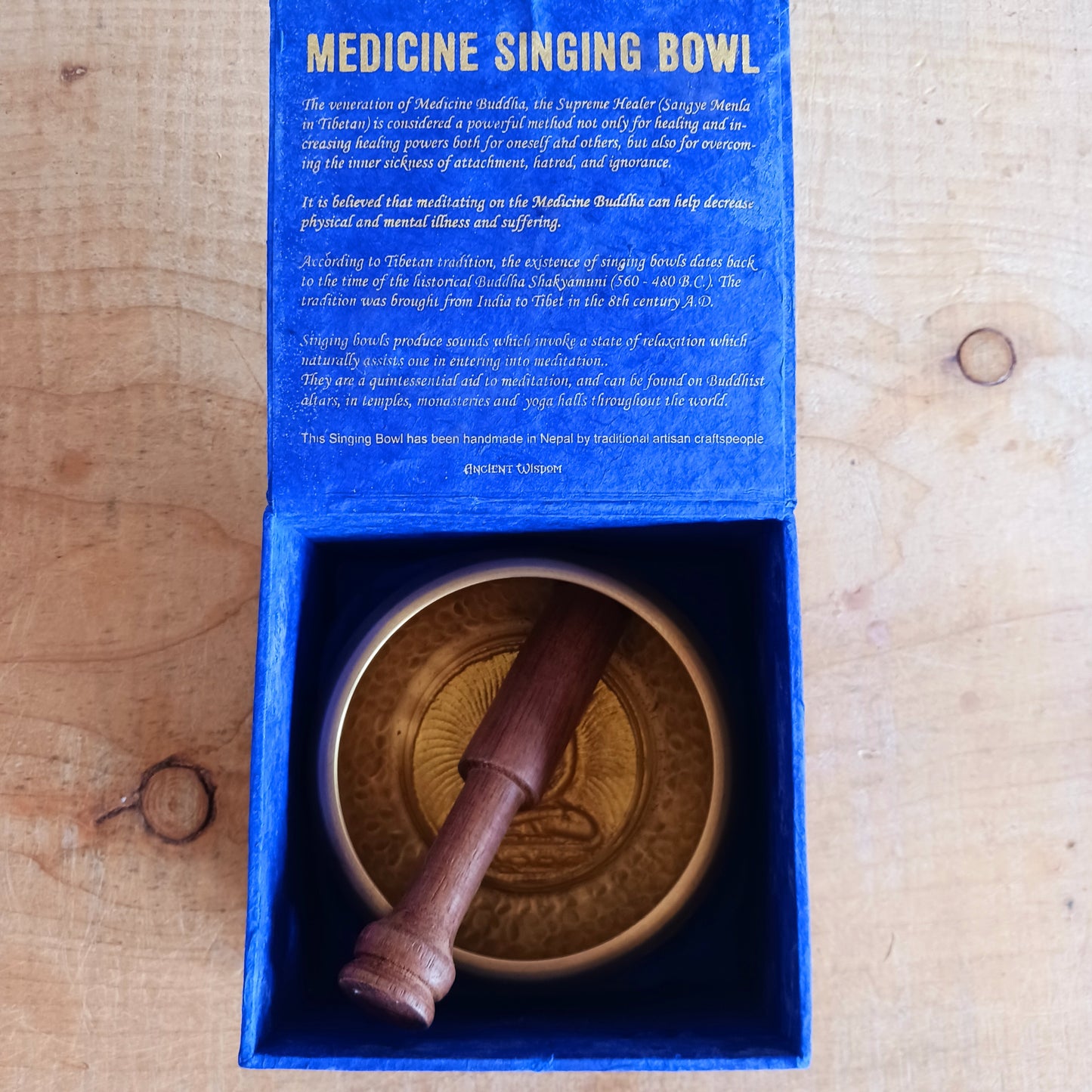 Elevate your practice with a hand-hammered Medicine Buddha singing bowl set, complete with cushion, striker, and symbolic gift box.