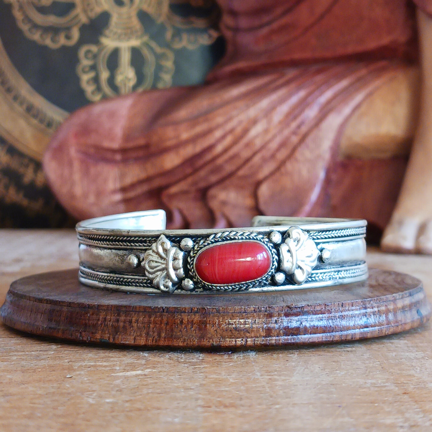 Add a touch of elegance and meaning to your jewellery collection with this handcrafted Nepalese bangle. Made from high-quality white metal, the bangle features a single coral stone.