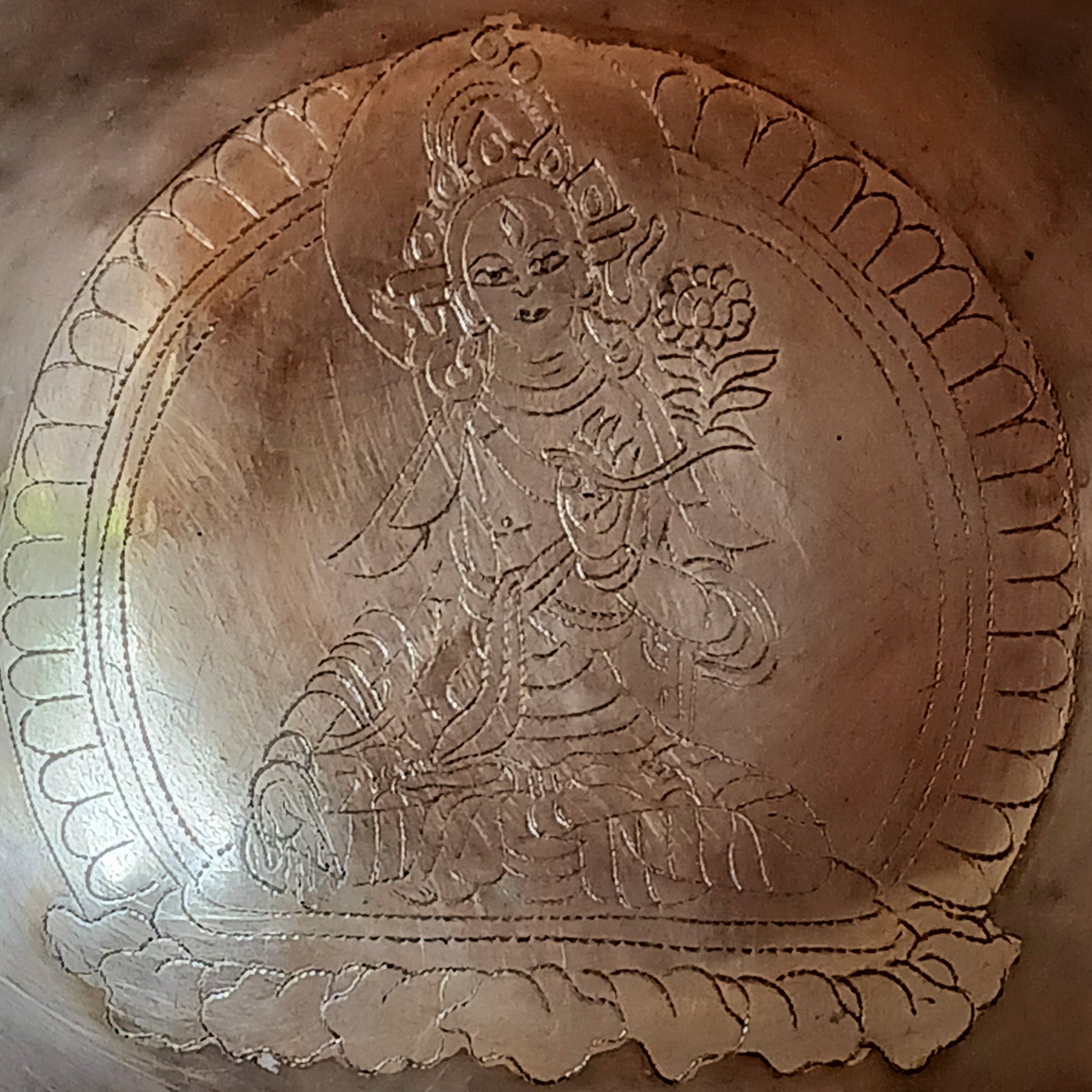 Elevate your spiritual practice with this unique, hand-beaten singing bowl, featuring a stunning Green Tara engraving inside the bowl. Known as the goddess of compassion and action, Green Tara is a powerful symbol in Tibetan Buddhism, bringing calm, protection, and clarity to your space. This bowl produces rich, resonant tones perfect for meditation, sound healing, or sacred decor.