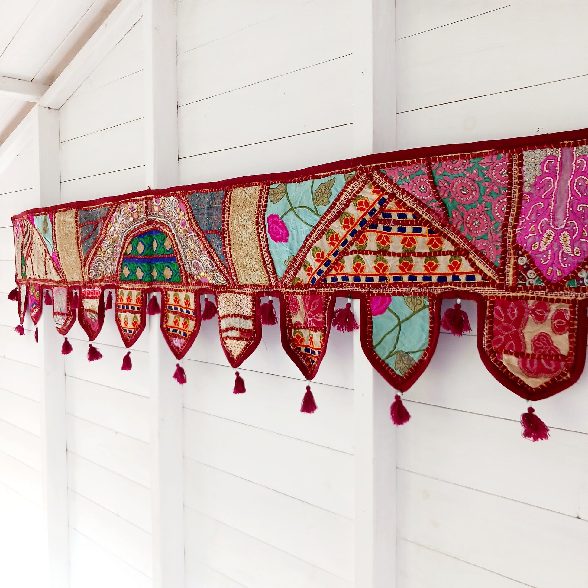 This long and beautifully intricate Indian Toran has been handmade from patches of vintage fabrics, wedding saris and recycled fabrics.  It will be a unique addition to any home and bring vibrancy of colour and embellishment.
