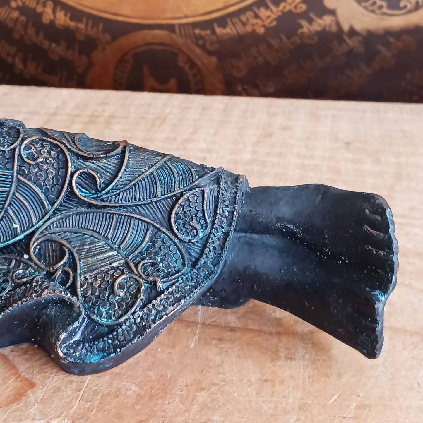 The statue features the Buddha in a graceful reclining pose, symbolizing his entry into nirvana. His left arm rests peacefully by his side, while his right hand cradles his head in a gesture of repose. The robe is intricately adorned with bodhi leaf motifs—sacred symbols of enlightenment and spiritual awakening.