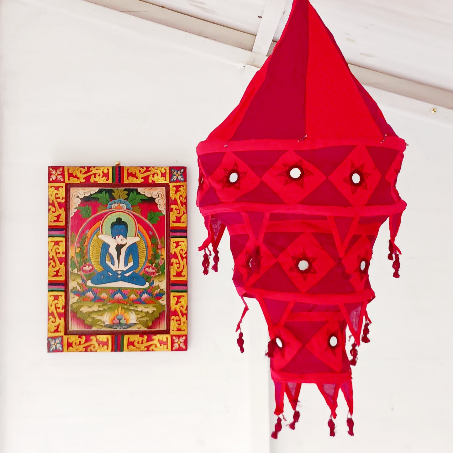 Bring colour, culture, and warmth into your space with this traditional handmade cotton Jhumar lampshade from Nepal. Carefully crafted by skilled artisans, each lampshade is made from vibrant cotton fabric and decorated with beautiful embroidered synthetic mirrors, creating a unique and eye-catching design.