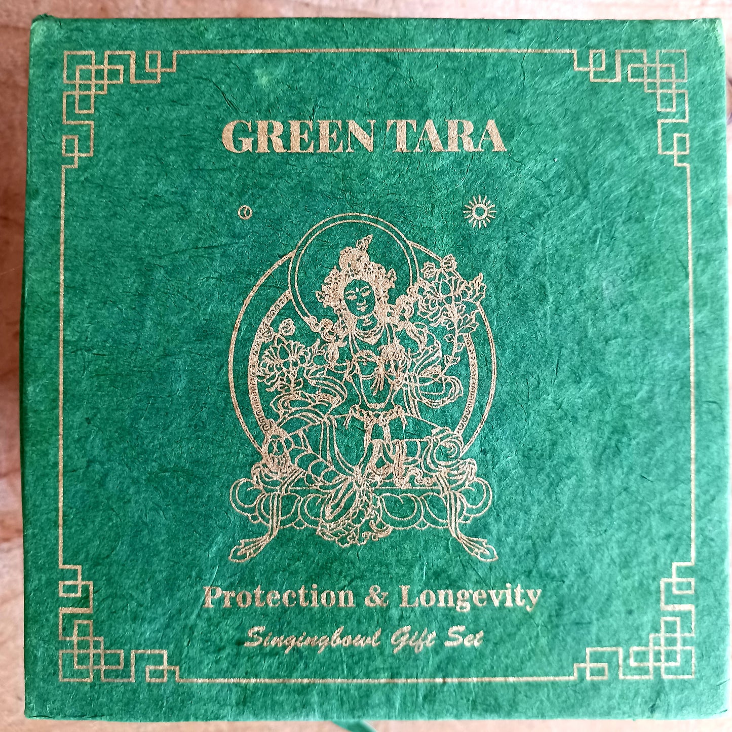 Green Tara singing bowl gift set packaging with gold text and illustration on a green background