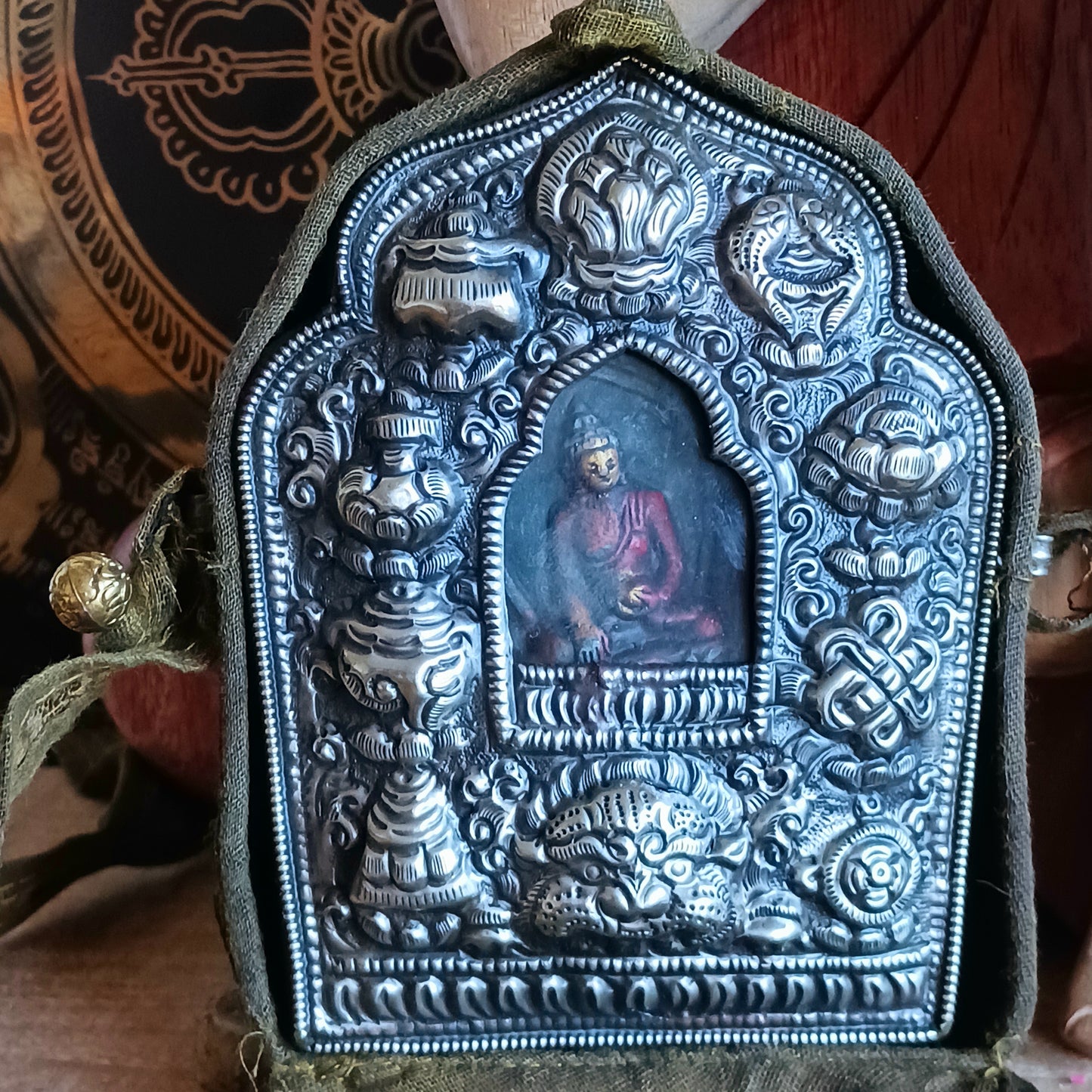 Discover the spiritual power of the Tibetan Ghau, a portable shrine and traditional prayer box used to carry sacred relics, charms, and medicinal herbs. Crafted by skilled Tibetan refugee artisans in Nepal, each Ghau serves as a portable shrine offering protection and blessings during travel. Wear it as a pendant around your neck or hang it from a waist sash or belt. This handcrafted piece is not only a spiritual talisman but also a beautiful work of art, connecting you to centuries-old Tibetan traditions.