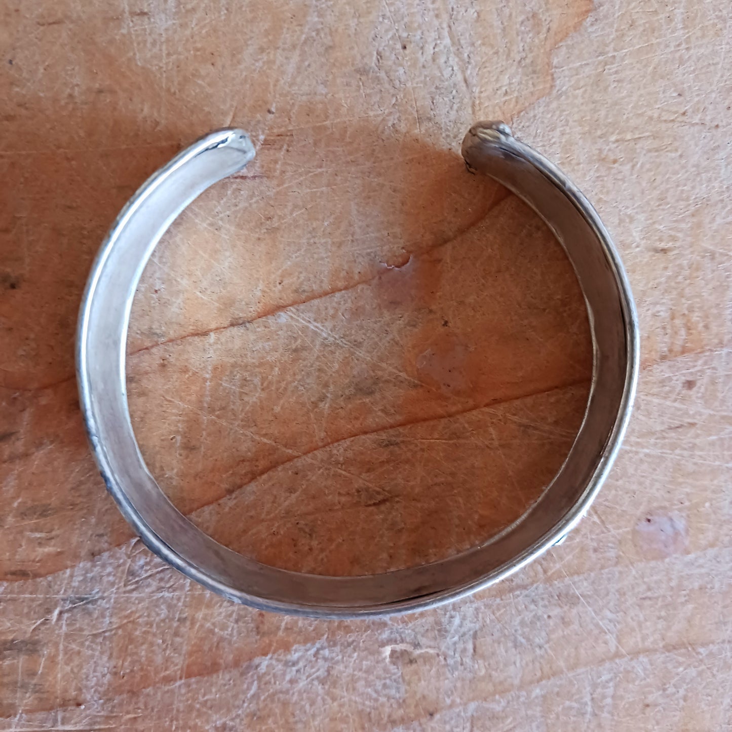 This Tibetan adjustable mantra bangle is a timeless piece of spiritual jewellery, handcrafted by skilled artisans in Nepal. Made from traditional Tibetan White Metal, the bangle features two small coral stones and engraved script inspired by ancient Tibetan culture and symbolism.