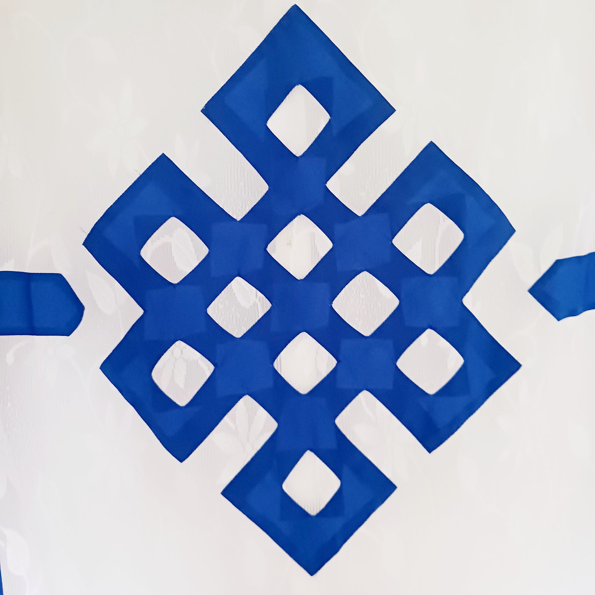 Bring spiritual harmony and traditional Himalayan craftsmanship into your home with this handmade Tibetan Buddhist Endless Knot Door Curtain. Crafted in a white fabric, this semi-transparent curtain allows natural light to pass through, creating a warm and calming atmosphere.