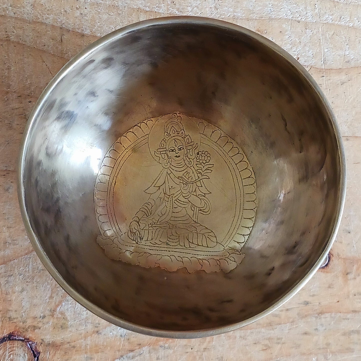 Elevate your spiritual practice with this unique, hand-beaten singing bowl, featuring a stunning Green Tara engraving inside the bowl. Known as the goddess of compassion and action, Green Tara is a powerful symbol in Tibetan Buddhism, bringing calm, protection, and clarity to your space. This bowl produces rich, resonant tones perfect for meditation, sound healing, or sacred decor.