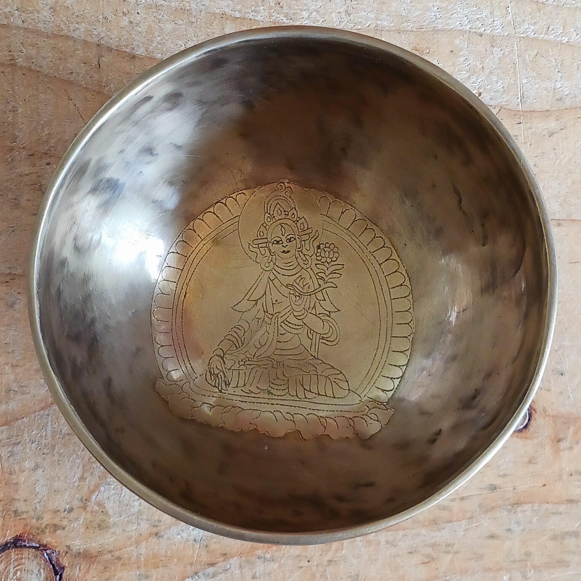 Elevate your spiritual practice with this unique, hand-beaten singing bowl, featuring a stunning Green Tara engraving inside the bowl. Known as the goddess of compassion and action, Green Tara is a powerful symbol in Tibetan Buddhism, bringing calm, protection, and clarity to your space. This bowl produces rich, resonant tones perfect for meditation, sound healing, or sacred decor.