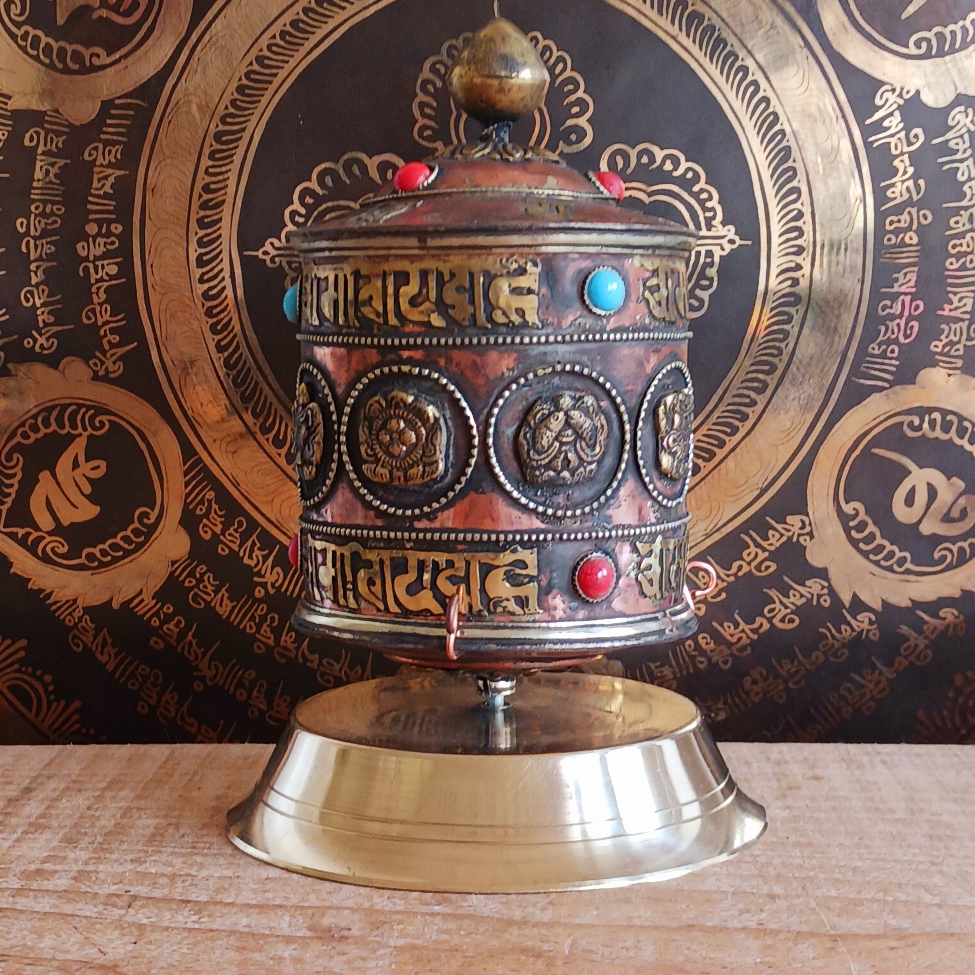Invite blessings, clarity, and compassion into your space with this handcrafted metal table-top prayer wheel. Beautifully adorned with the Eight Auspicious Symbols, this sacred piece is both a devotional object and a stunning piece of spiritual art.