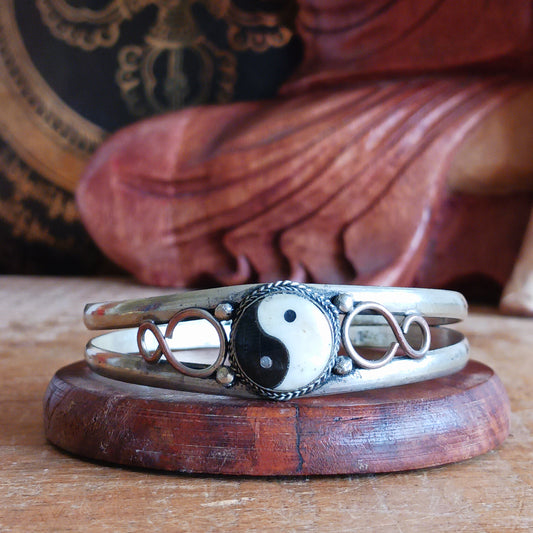 This white metal Yin Yang bracelet has been carefully hand crafted in local Nepalese workshops by skilled artisans. Each piece is individual its presented in a hand made traditional pouch. The pouches were designed to both utilize fabric left after garment production and to generate household employment for Nepali women. The production of these pouches began over 30 years ago and now 15-20 women are in continuous work within this project.