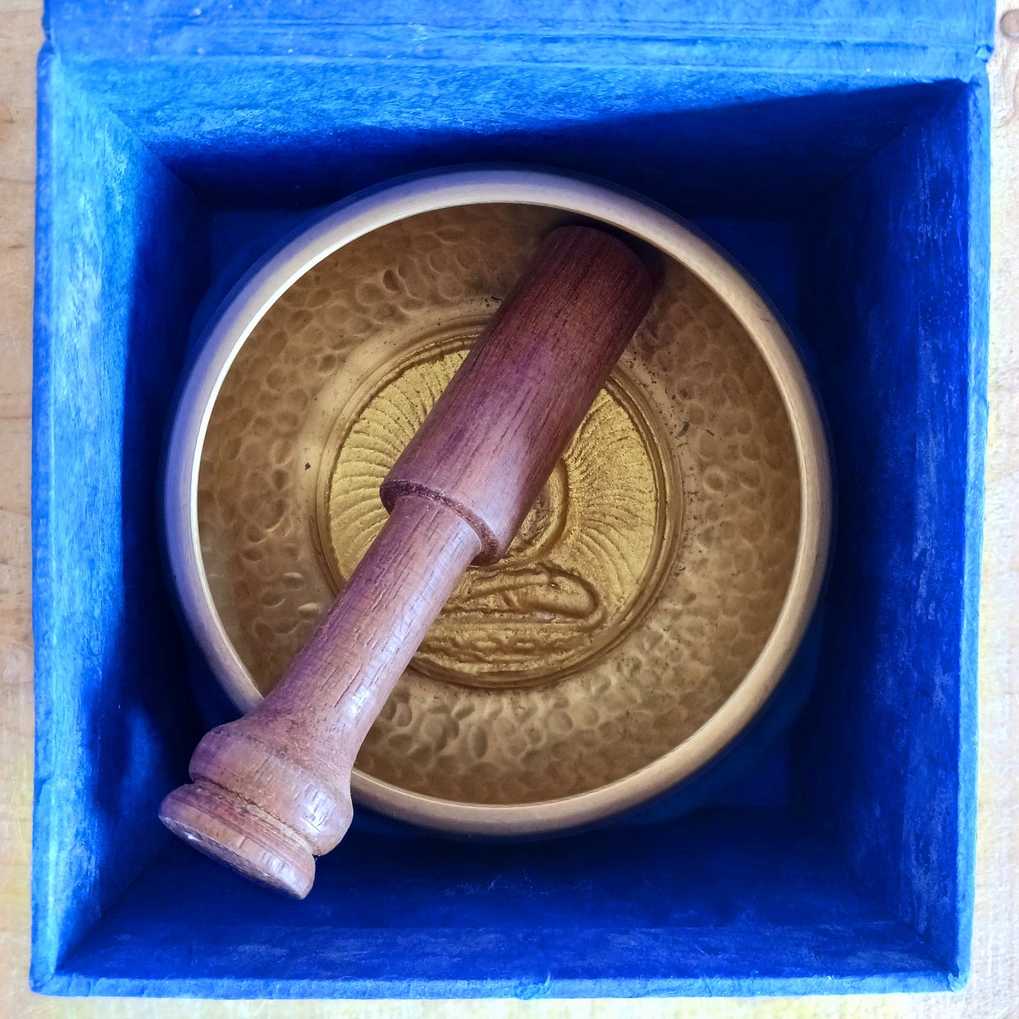 Elevate your practice with a hand-hammered Medicine Buddha singing bowl set, complete with cushion, striker, and symbolic gift box.