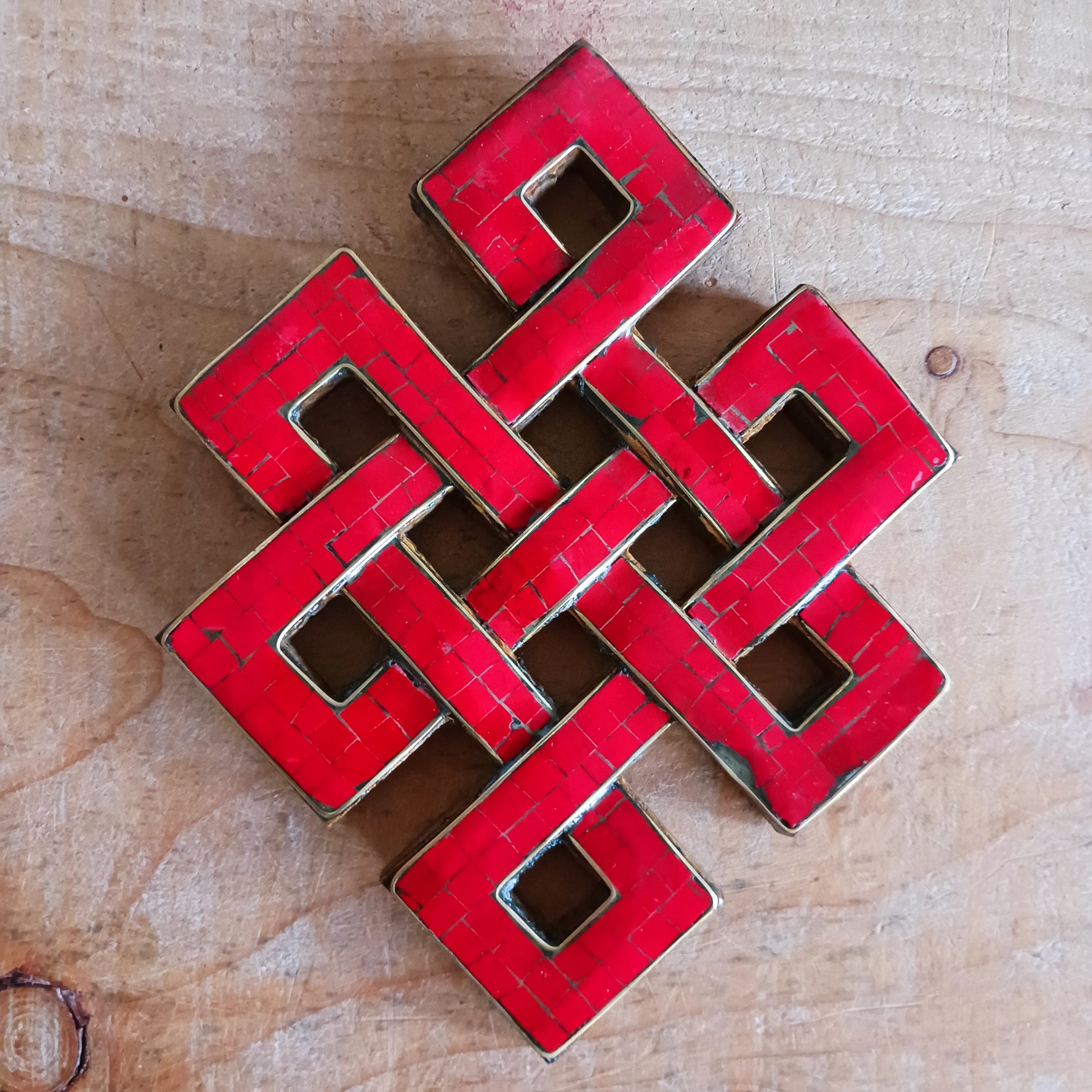 Add a touch of spiritual beauty and meaningful symbolism to your space with this hand-carved wooden Eternal (Endless) Knot wall décor. Carefully crafted by skilled artisans, each piece features coral stone chips inlaid into the carved wood, creating a stunning blend of natural texture and vibrant colour.