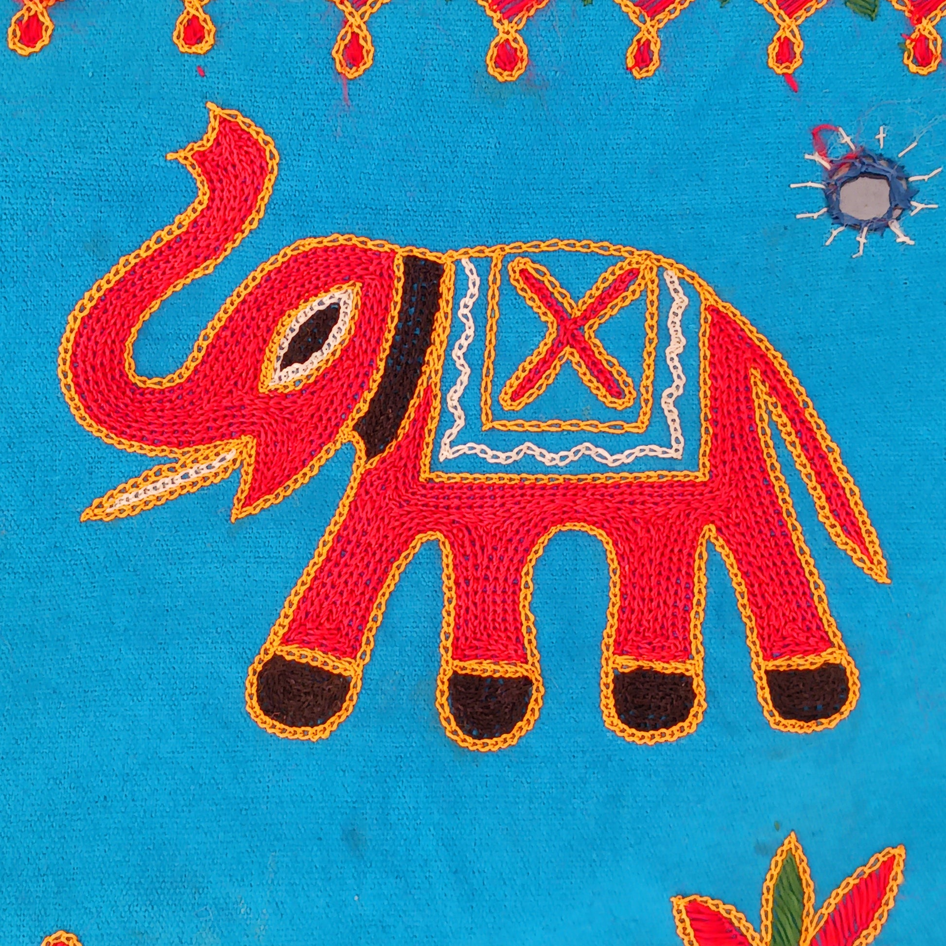 This beautiful turquoise Indian arch toran features two orange elephants with flowers either side and is adorned with mirrors and finished with tassels. This lovely toran has been meticulously hand-sewn and beautifully finished.  It really is a unique work of art.