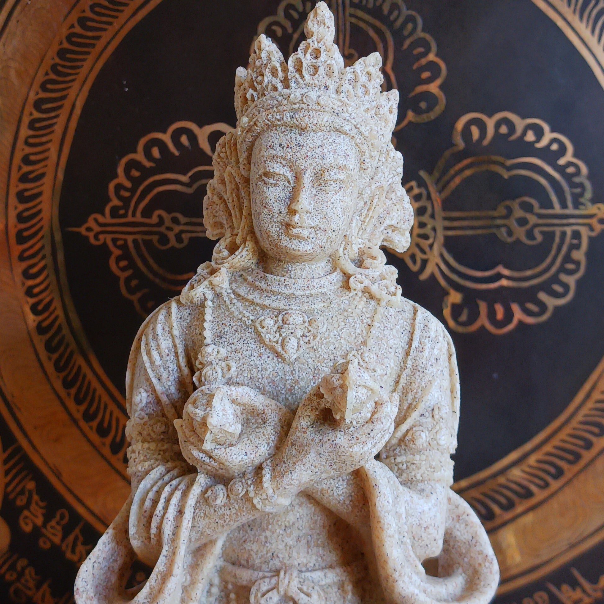 Elevate your sacred space with this beautifully crafted Sand Buddha Statue, inspired by traditional designs found in many Buddhist temples. Standing 17cm tall, this serene figure holds a Bell &amp; Dorje, symbolizing wisdom and compassion in perfect harmony.