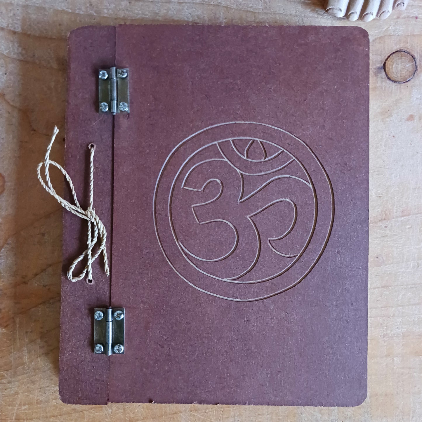 Capture your thoughts, ideas, and inspirations in this beautifully crafted hard-covered notebook. Featuring a hinged design and filled with eco-friendly recycled Lokta paper, it’s perfect for jotting down notes on the go. Each notebook is elegantly engraved with the Om symbol on the front cover, adding a touch of mindfulness and serenity to your writing. Ideal for journaling, sketching, or as a thoughtful gift for loved ones.