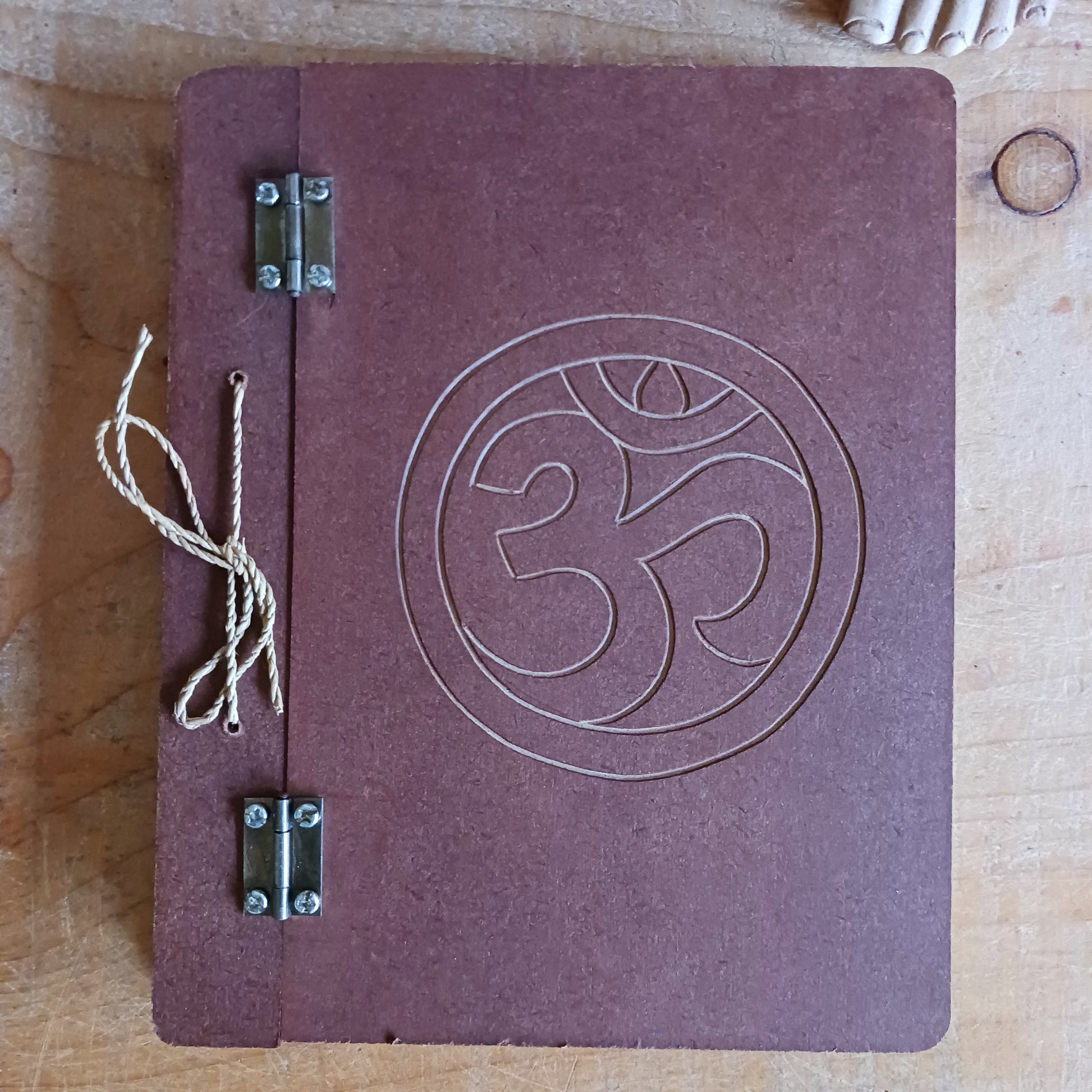 Capture your thoughts, ideas, and inspirations in this beautifully crafted hard-covered notebook. Featuring a hinged design and filled with eco-friendly recycled Lokta paper, it’s perfect for jotting down notes on the go. Each notebook is elegantly engraved with the Om symbol on the front cover, adding a touch of mindfulness and serenity to your writing. Ideal for journaling, sketching, or as a thoughtful gift for loved ones.